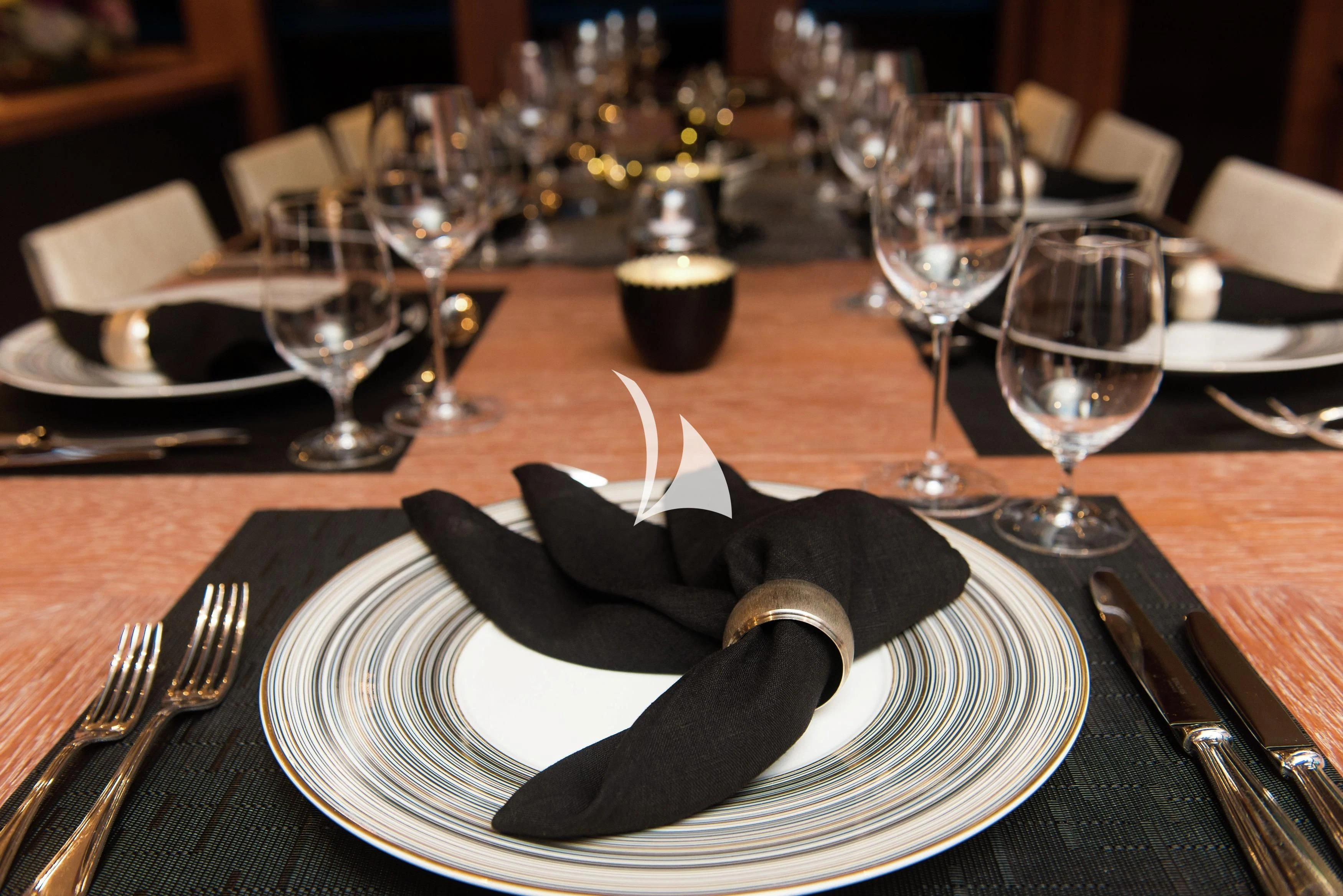 a plate with a napkin and glasses on it aboard STEALTH Yacht for Sale