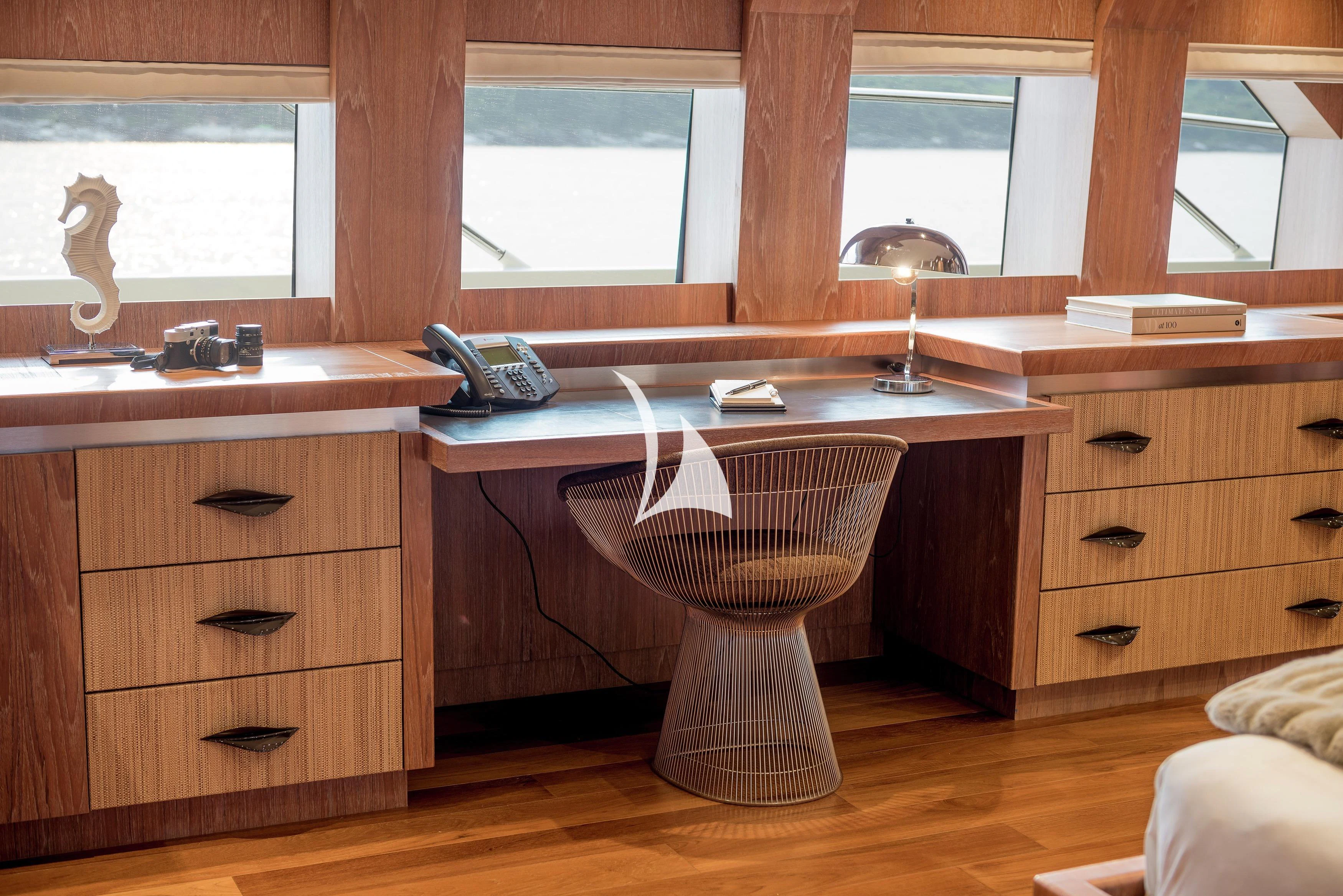 a desk with a lamp and a computer on it aboard STEALTH Yacht for Sale
