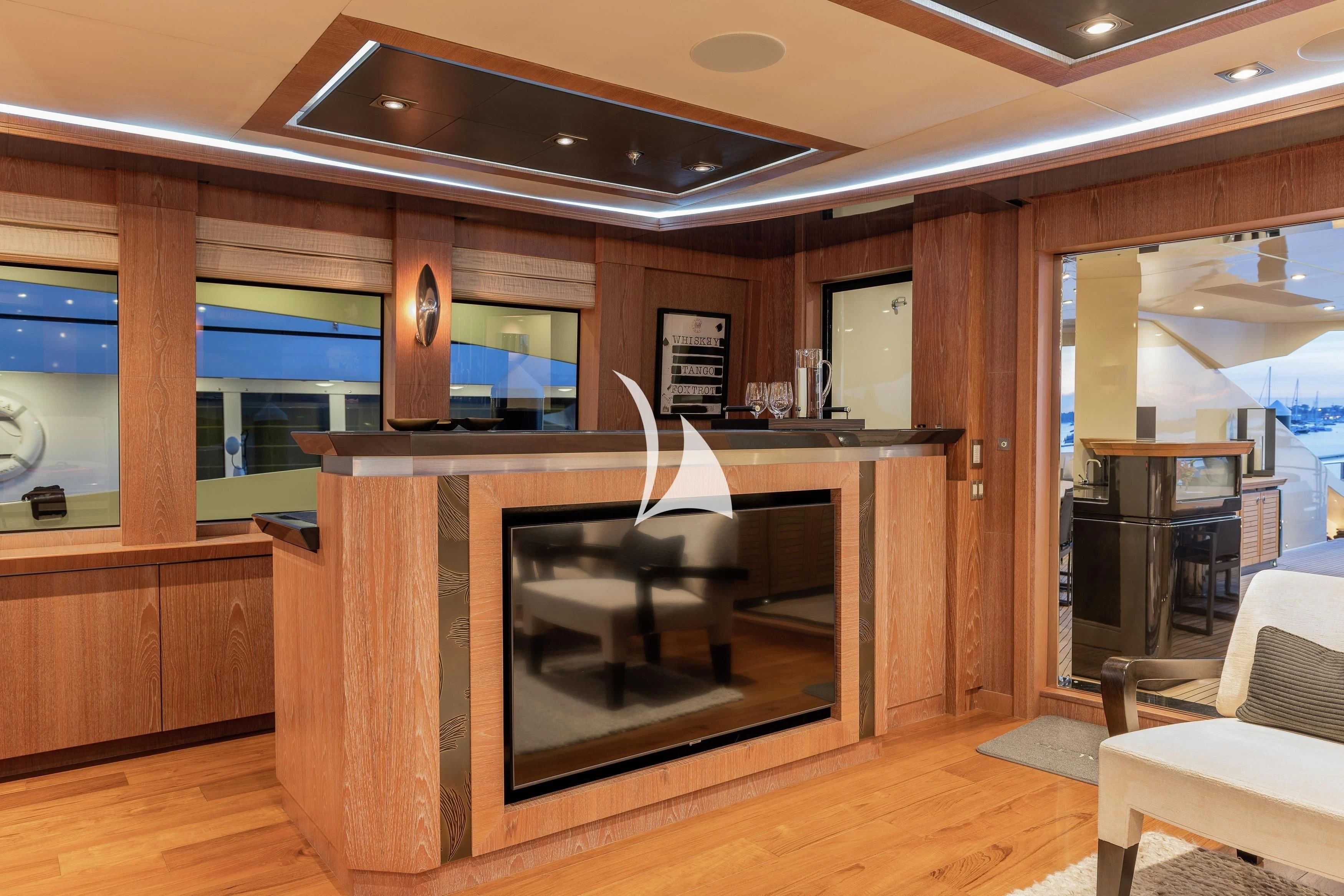 a room with a large tv and a table aboard STEALTH Yacht for Sale