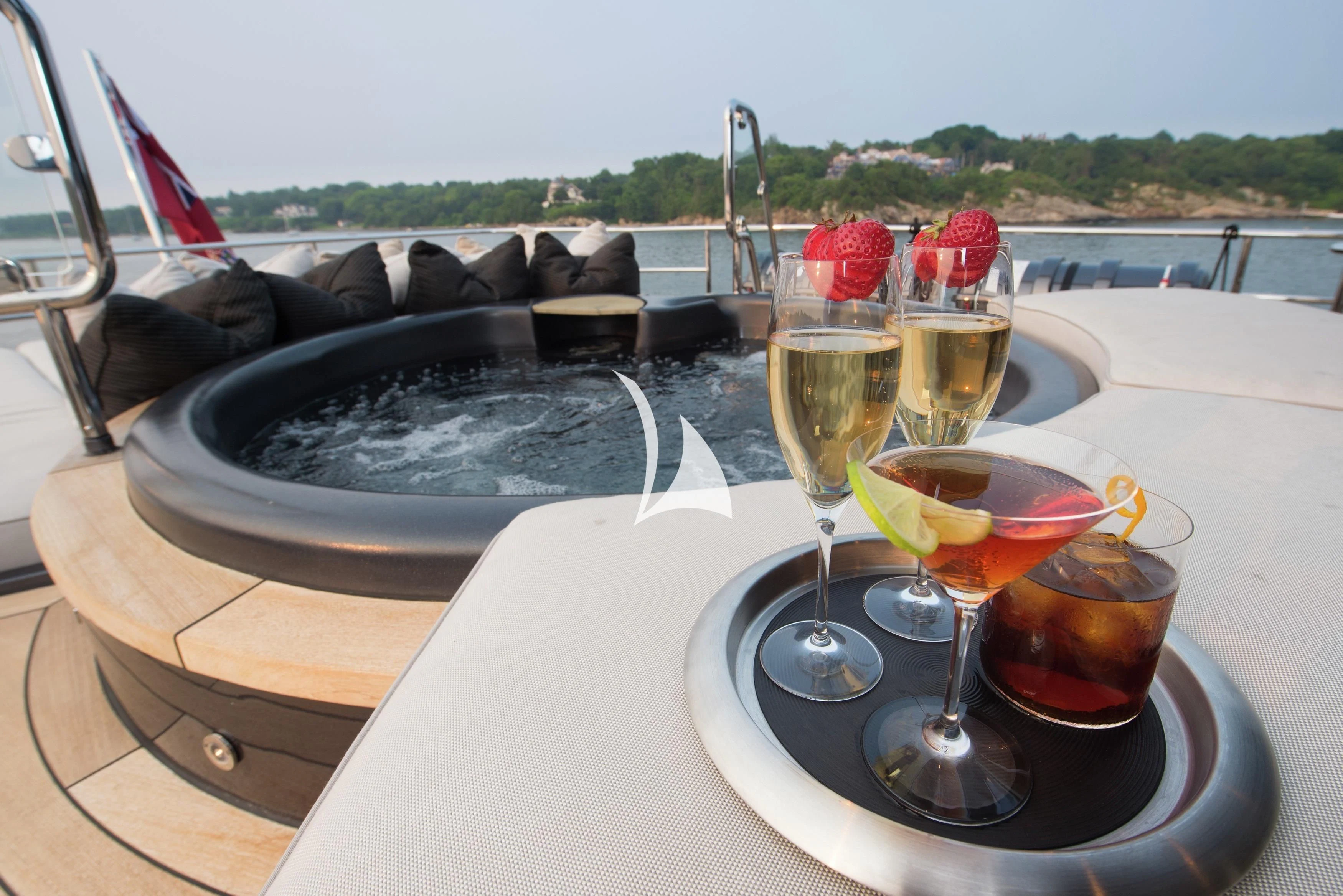 a group of glasses of wine on a table with a view of the water and a boat in aboard STEALTH Yacht for Sale