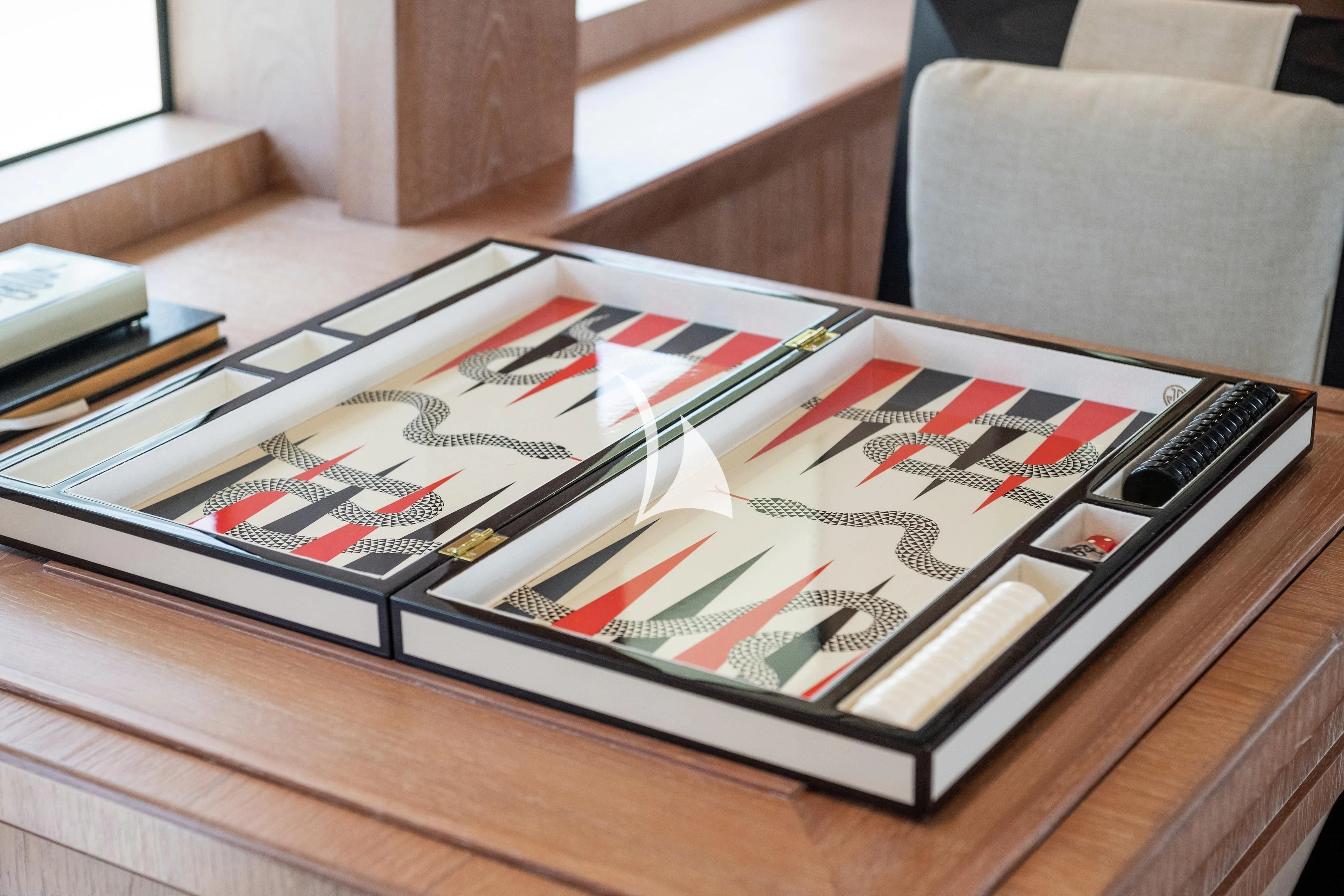 a wooden table with a game board and a game controller on it aboard STEALTH Yacht for Sale