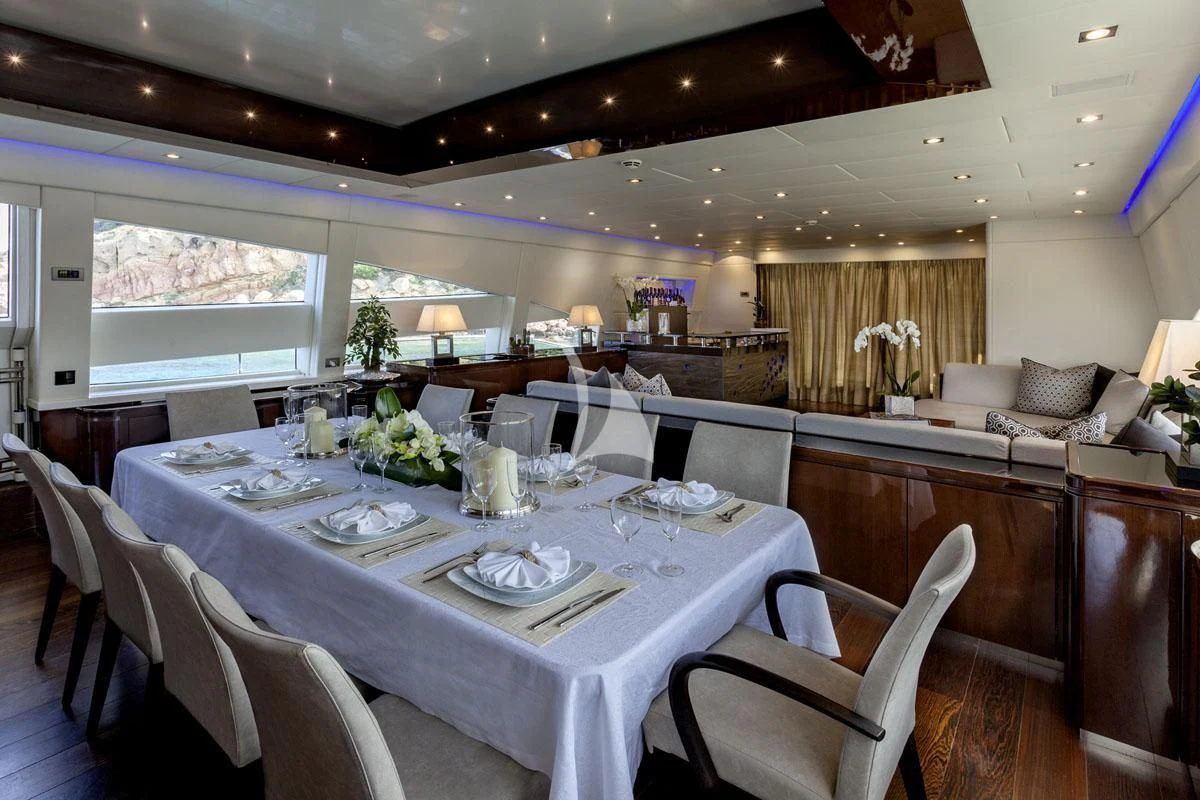 a dining room with a table set for a dinner aboard MY TOY Yacht for Sale