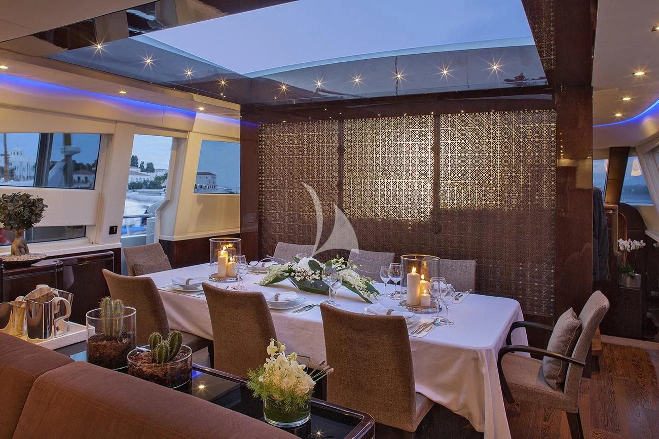 a table with chairs and a large window aboard MY TOY Yacht for Sale