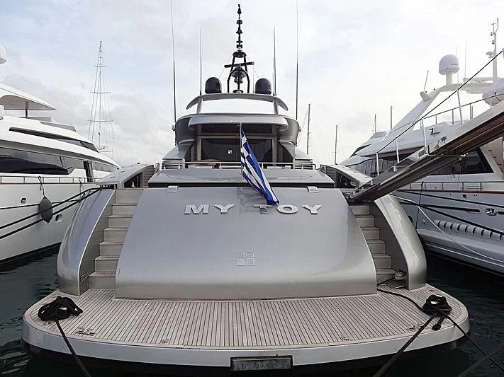 a large white boat with a flag on it aboard MY TOY Yacht for Sale