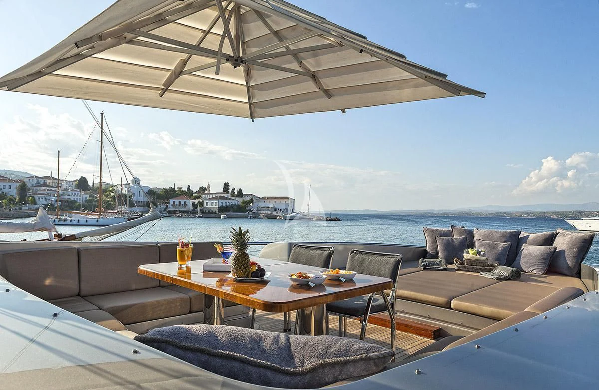 a table and chairs on a deck overlooking a body of water aboard MY TOY Yacht for Sale