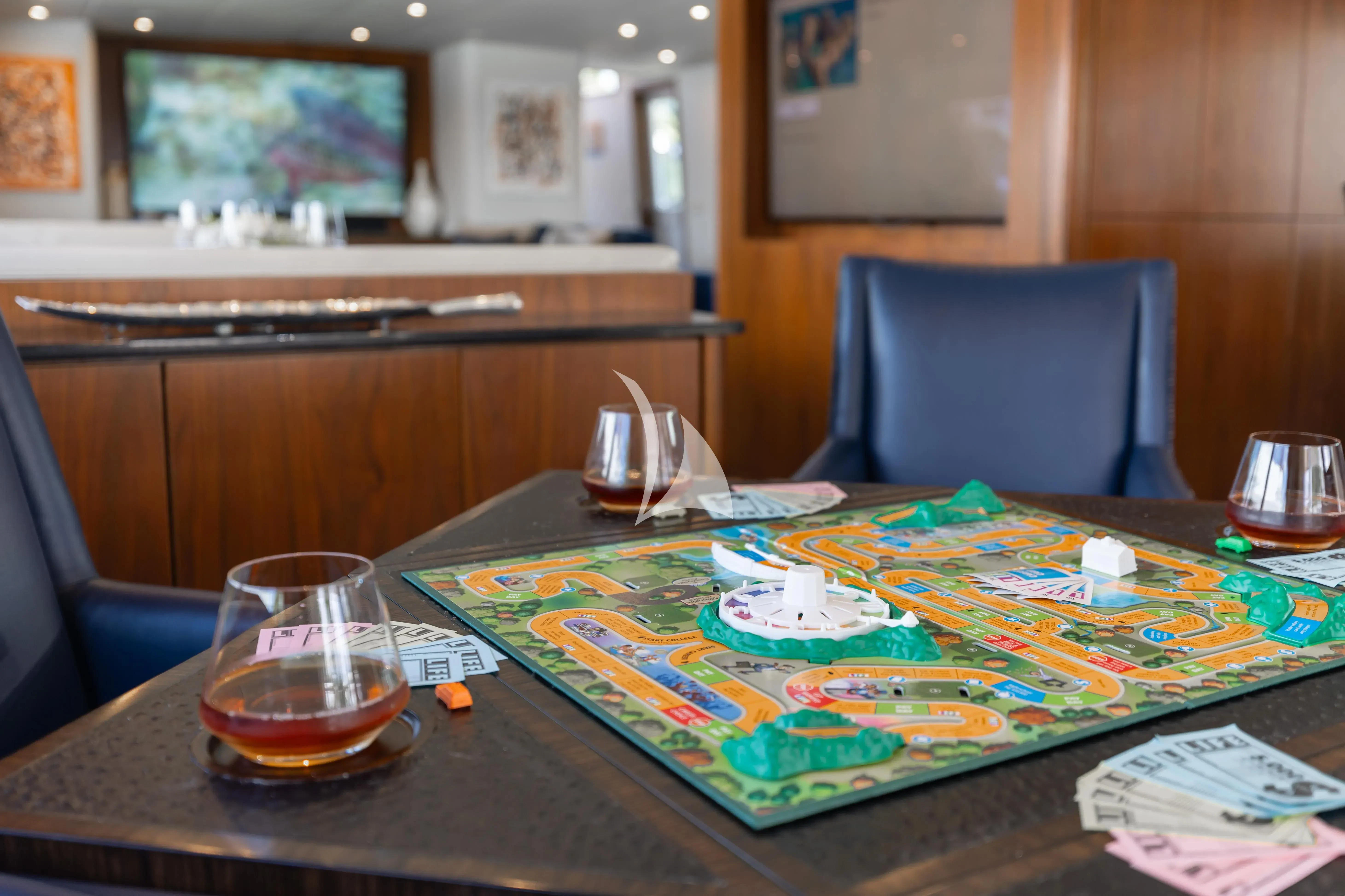a table with a glass of beer and a plate of food aboard A PLACE IN THE SUN Yacht for Sale