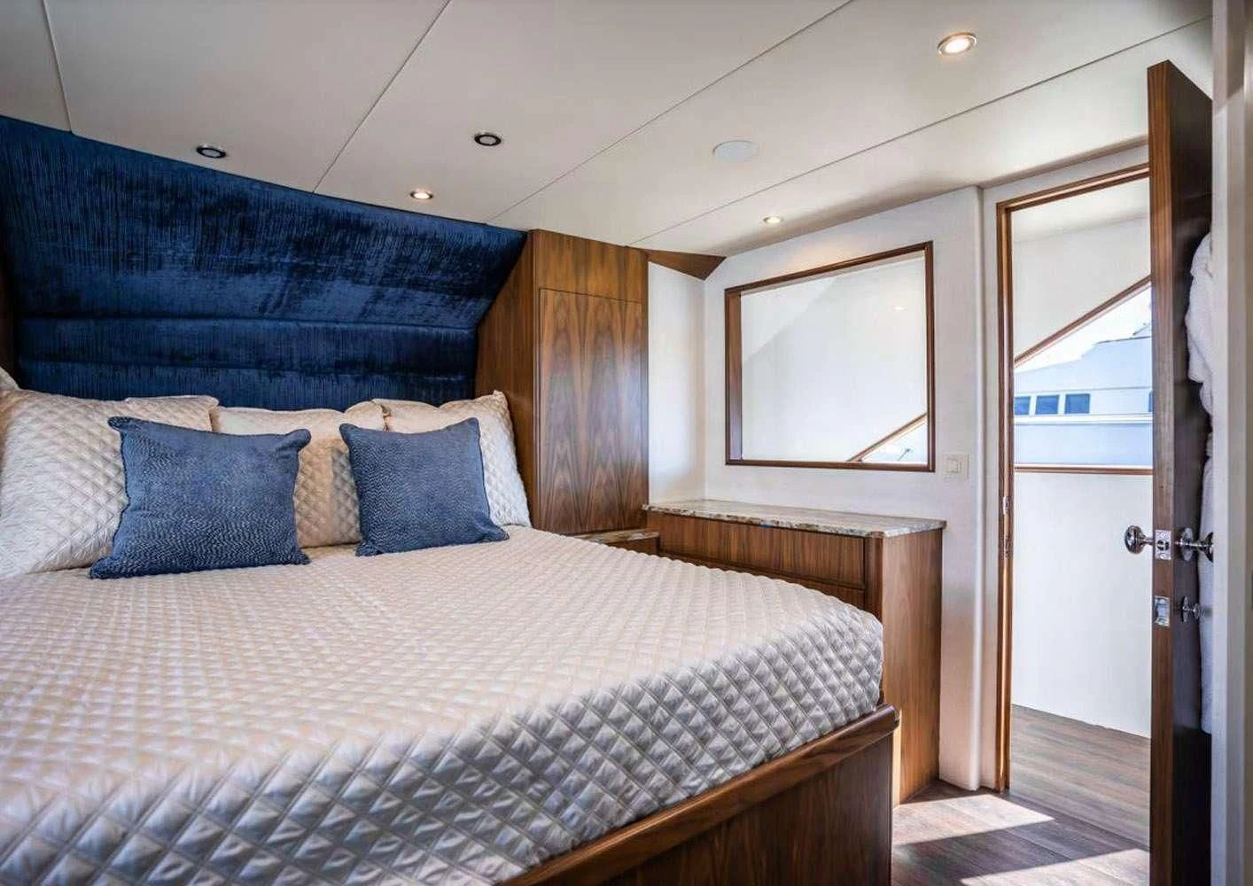 a bed with a blue and white comforter and pillows aboard A PLACE IN THE SUN Yacht for Sale