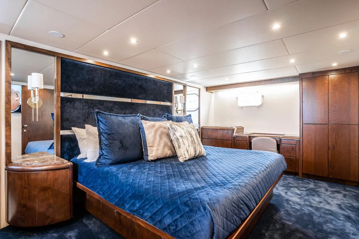 a bed with a blue comforter aboard A PLACE IN THE SUN Yacht for Sale