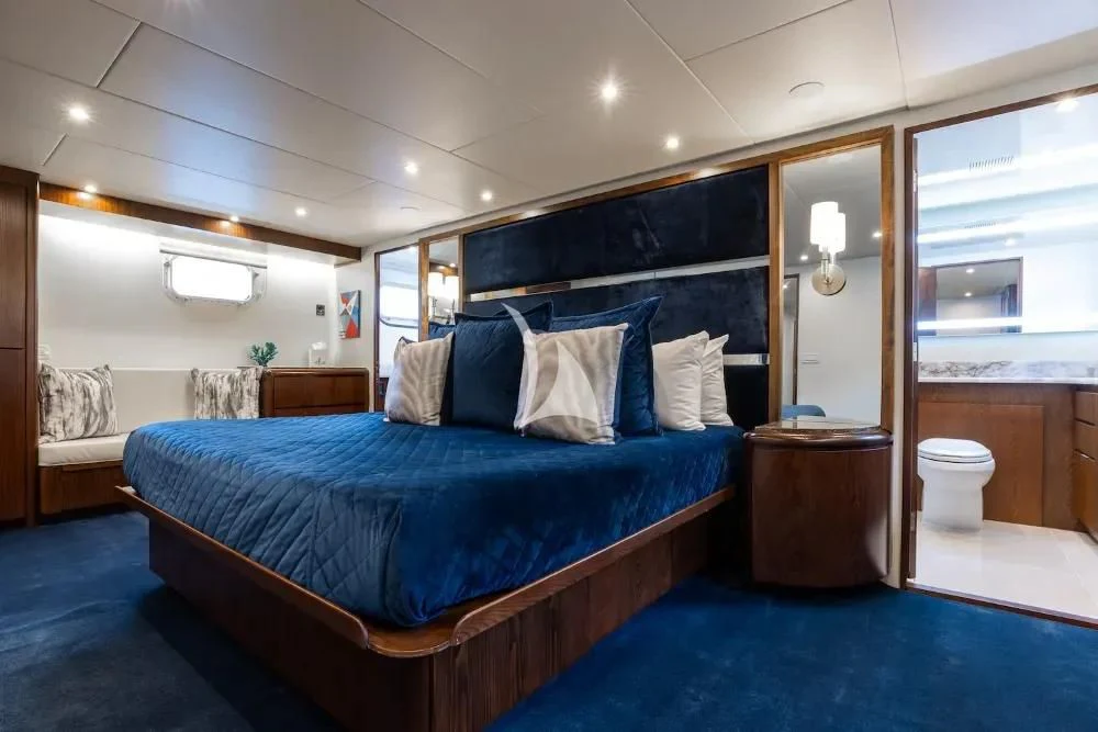 a bedroom with a blue bed aboard A PLACE IN THE SUN Yacht for Sale