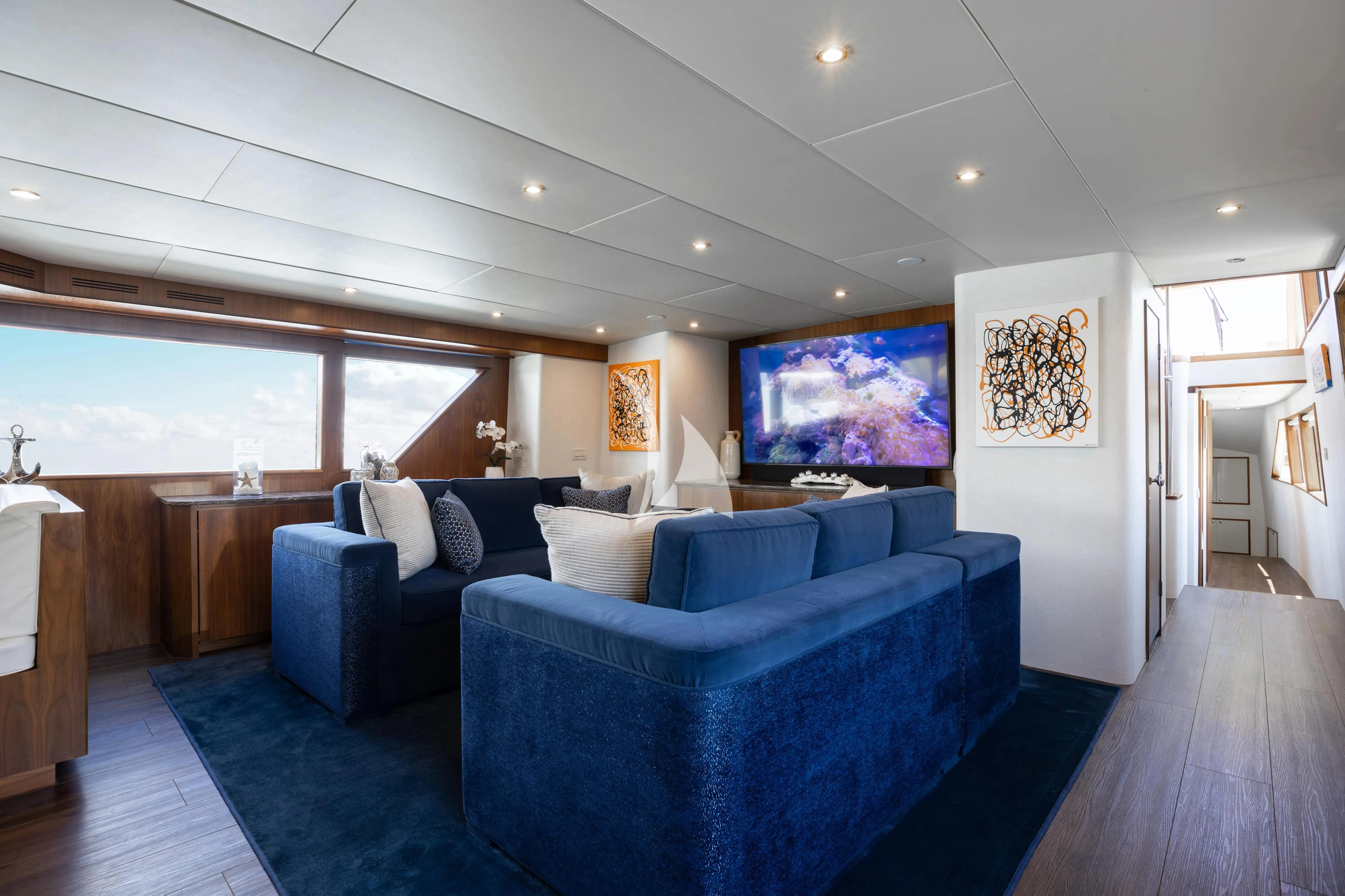 a living room with a blue couch aboard A PLACE IN THE SUN Yacht for Sale