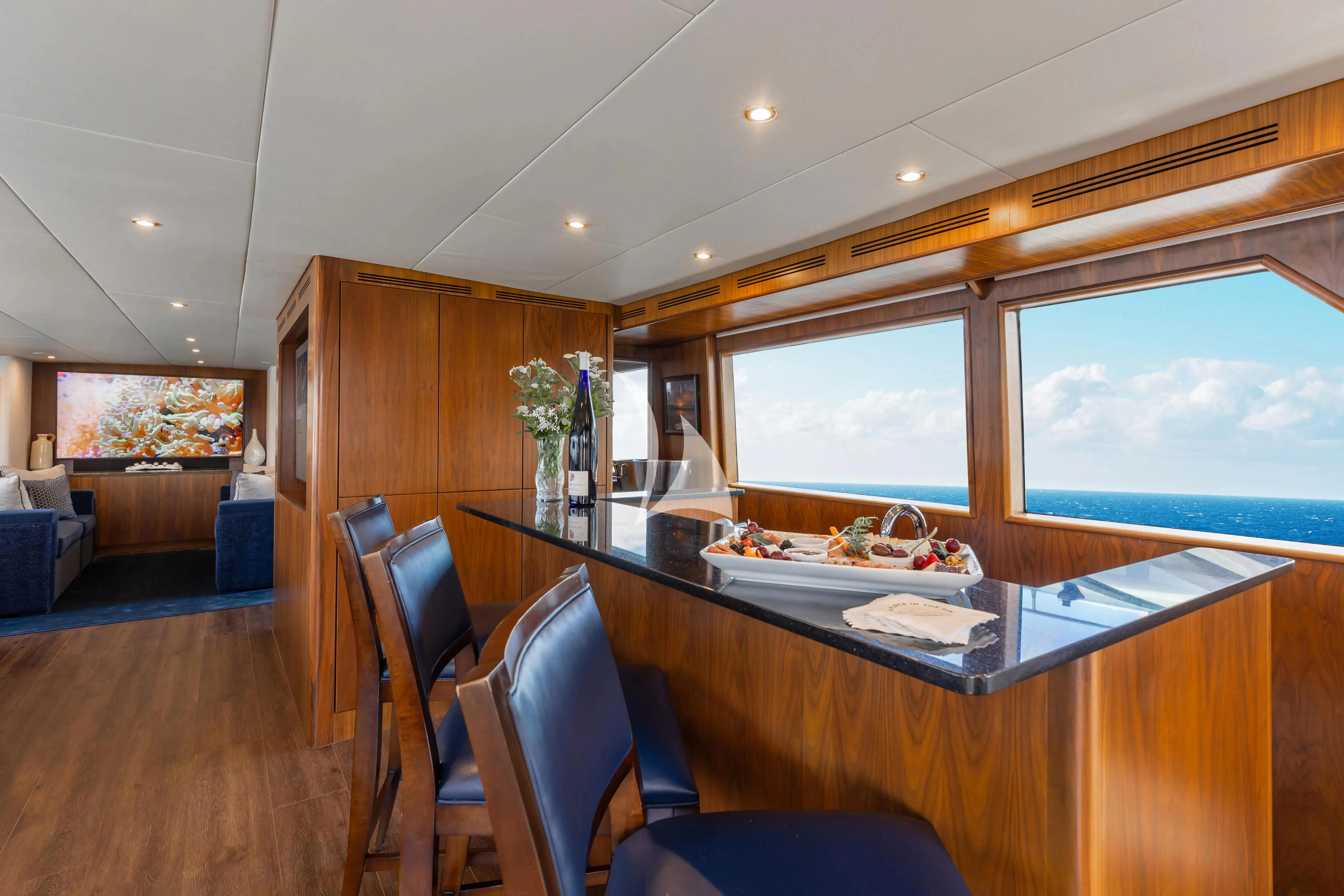 a dining room with a wood wall aboard A PLACE IN THE SUN Yacht for Sale