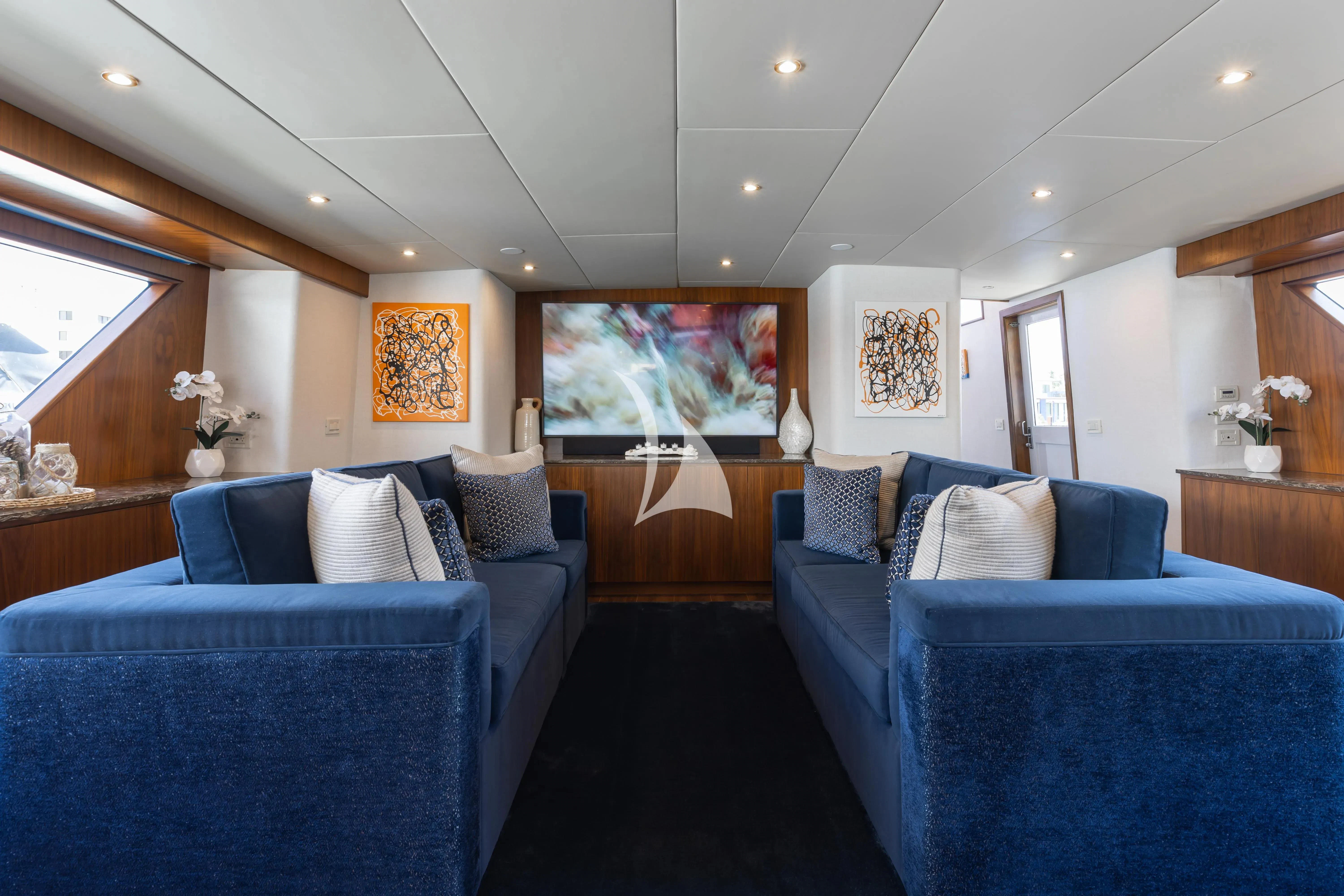 a room with blue couches aboard A PLACE IN THE SUN Yacht for Sale
