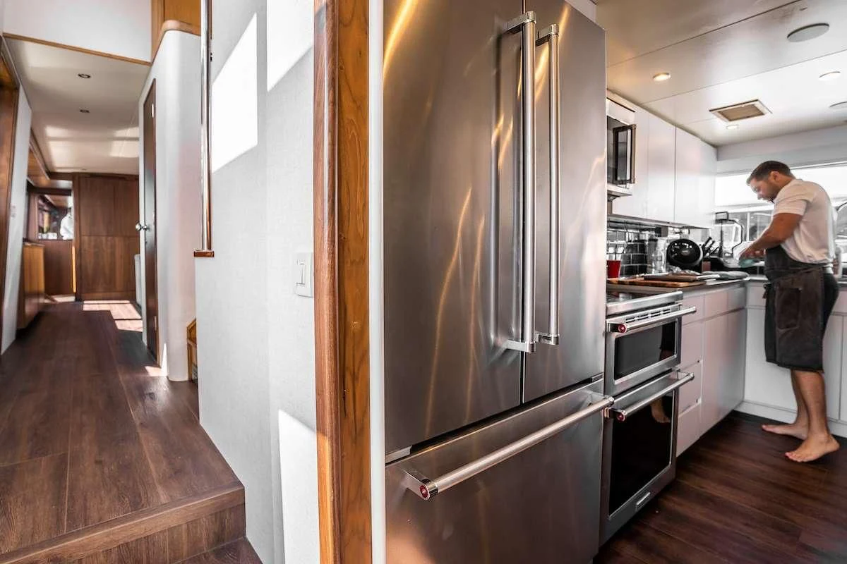 a person stands in a kitchen aboard A PLACE IN THE SUN Yacht for Sale