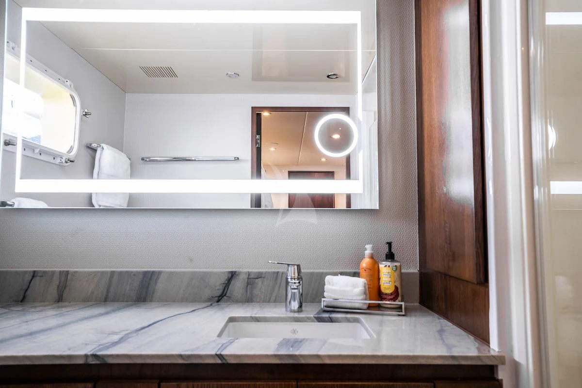 a bathroom with a countertop sink and mirror aboard A PLACE IN THE SUN Yacht for Sale