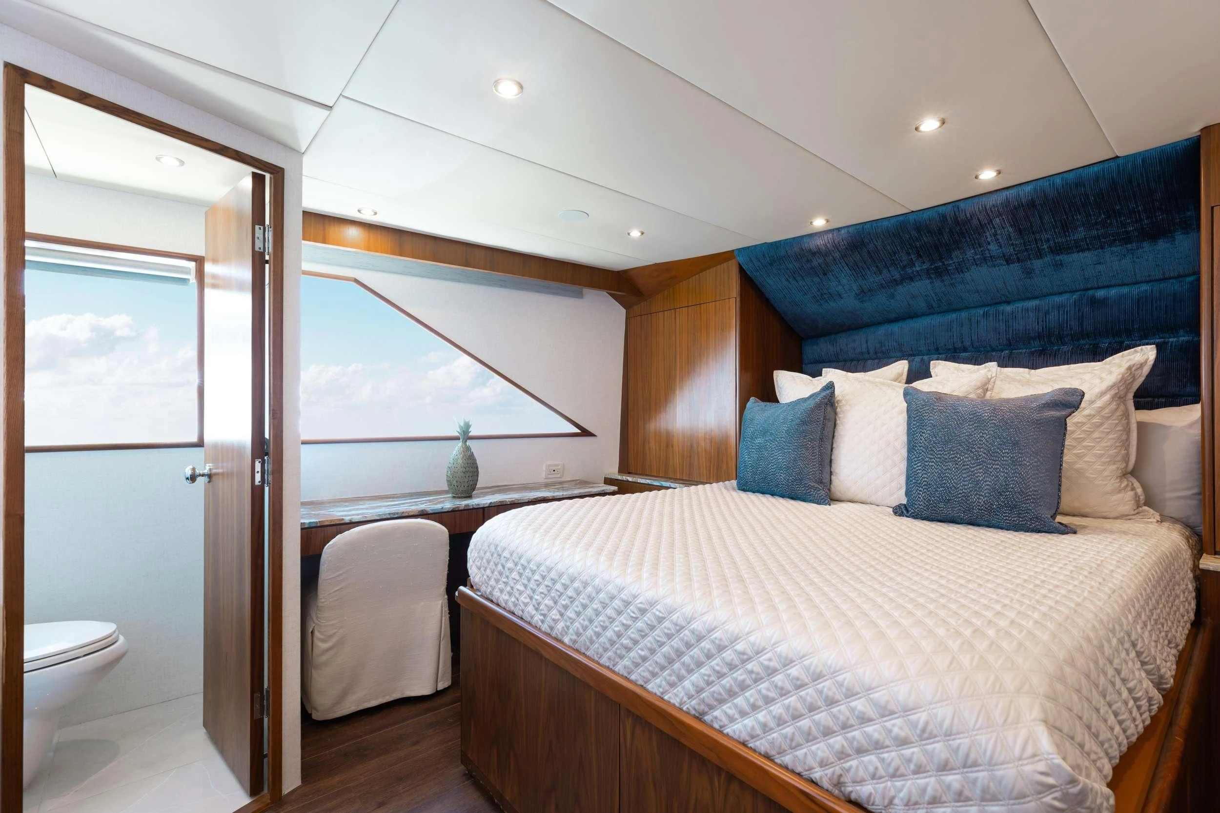 a bedroom with a bed and a table aboard A PLACE IN THE SUN Yacht for Sale