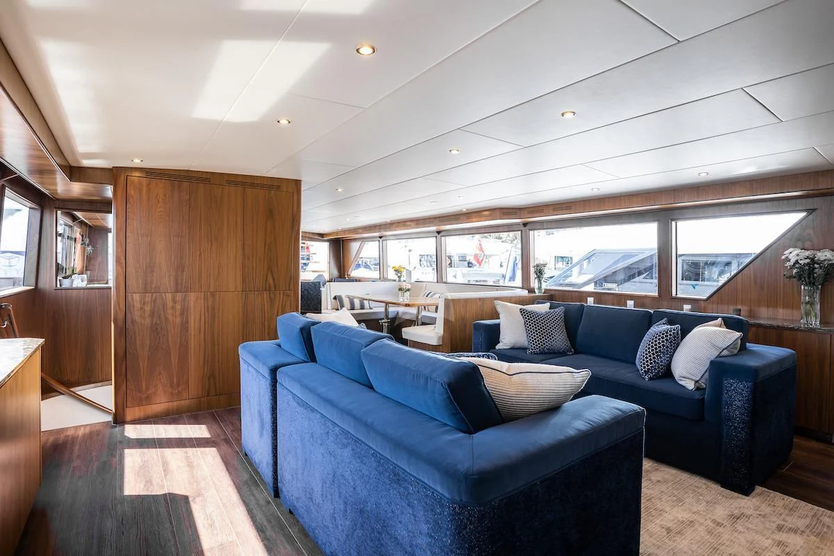 a living room with a blue couch aboard A PLACE IN THE SUN Yacht for Sale