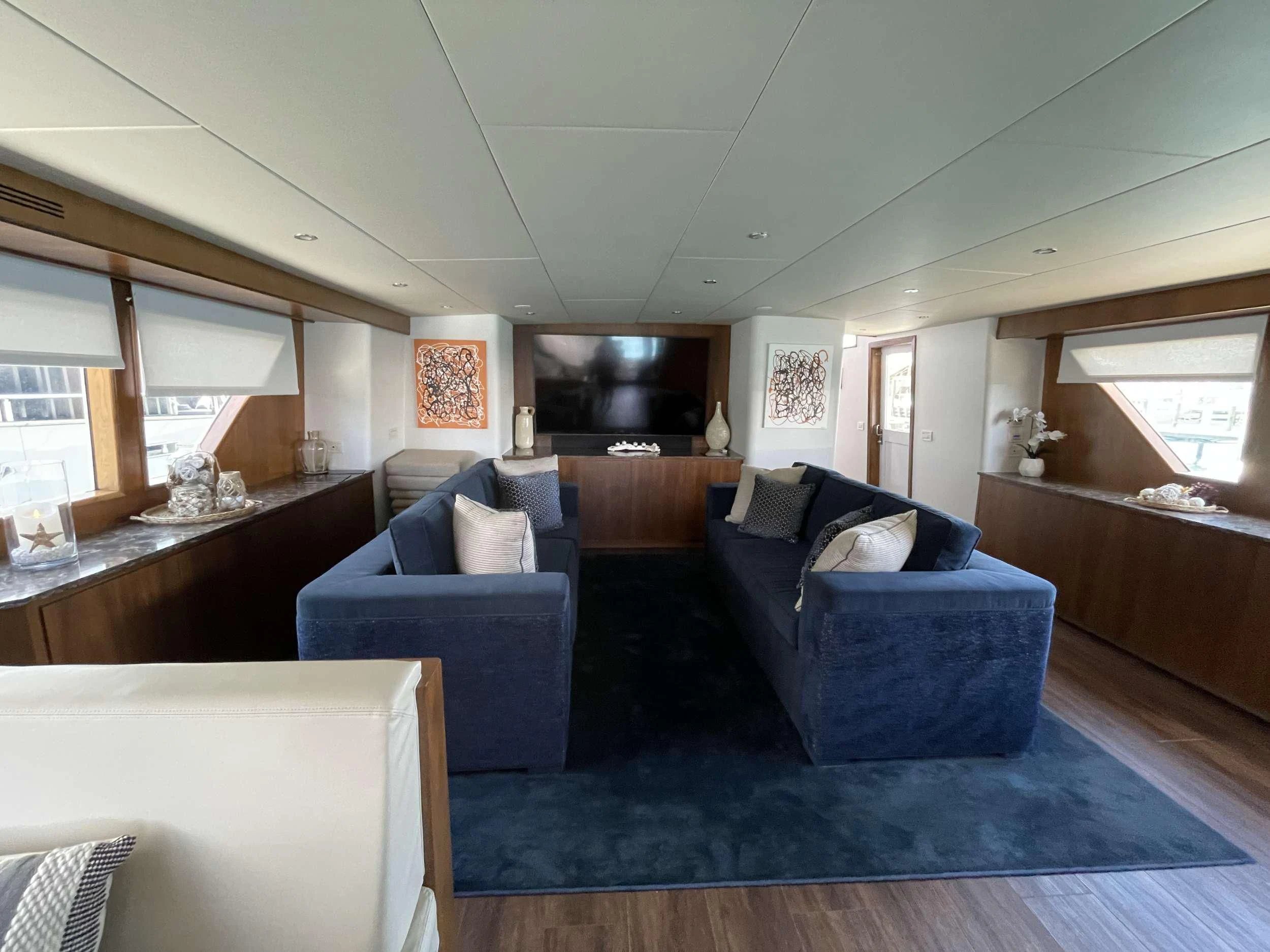 a living room with a blue couch aboard A PLACE IN THE SUN Yacht for Sale
