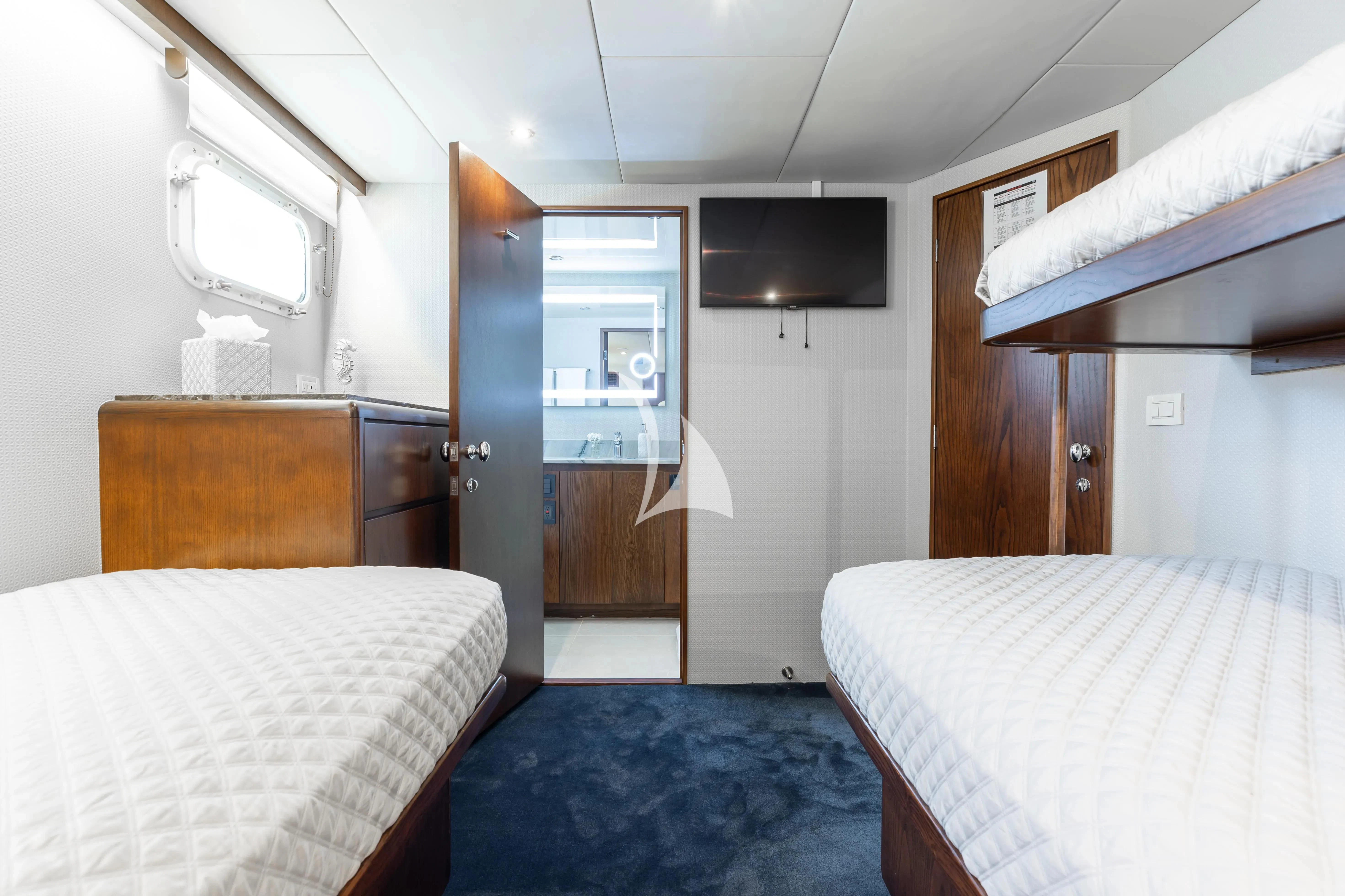a room with a bed and a television aboard A PLACE IN THE SUN Yacht for Sale
