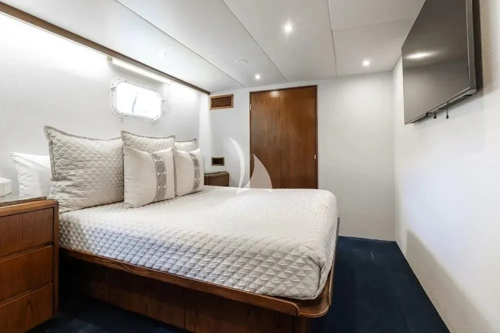 a bed with a white comforter aboard A PLACE IN THE SUN Yacht for Sale