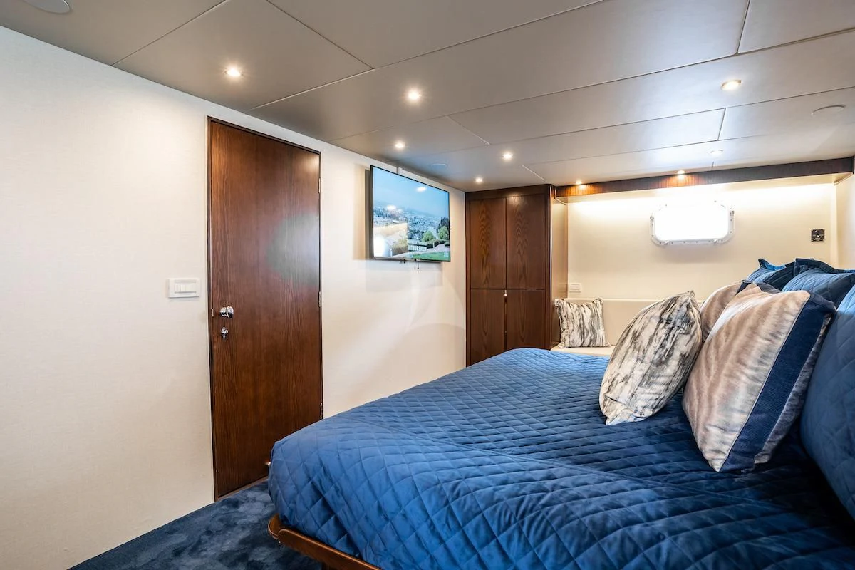 a bedroom with a bed and a closet aboard A PLACE IN THE SUN Yacht for Sale