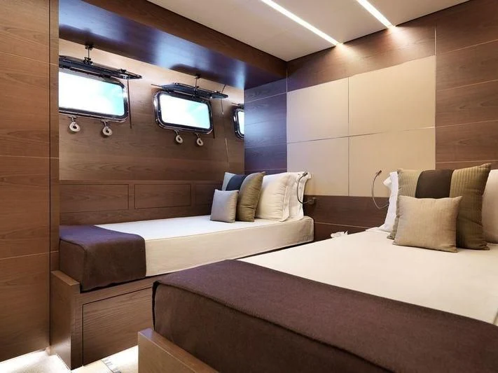 a room with a bed and a tv on the wall aboard NAIA Yacht for Sale