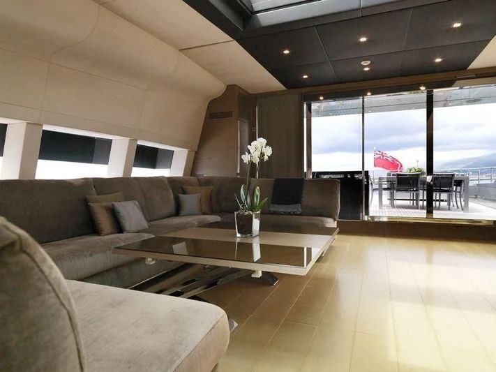 a living room with a table and couches aboard NAIA Yacht for Sale