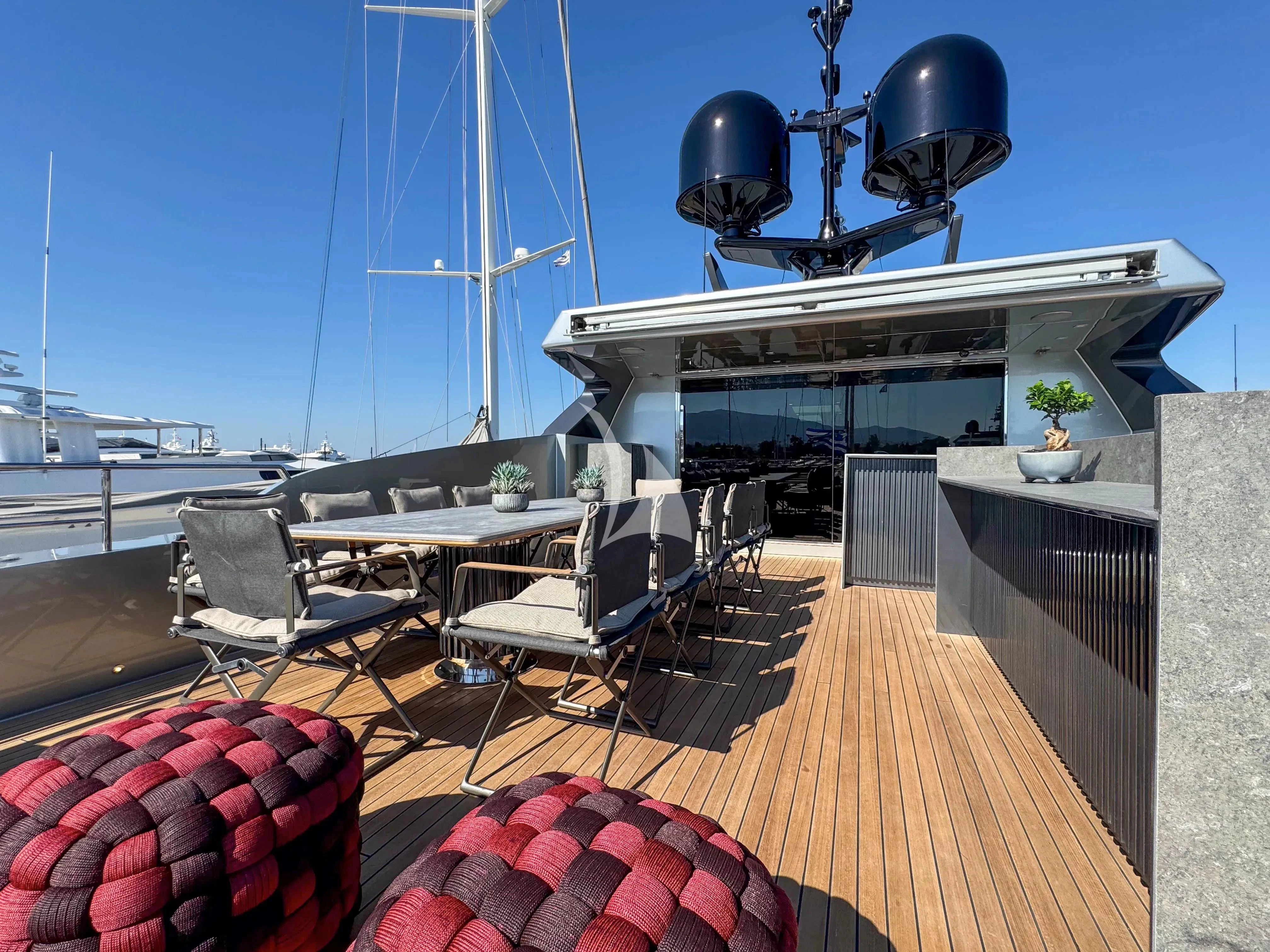 a deck with a table and chairs on it aboard NAIA Yacht for Sale