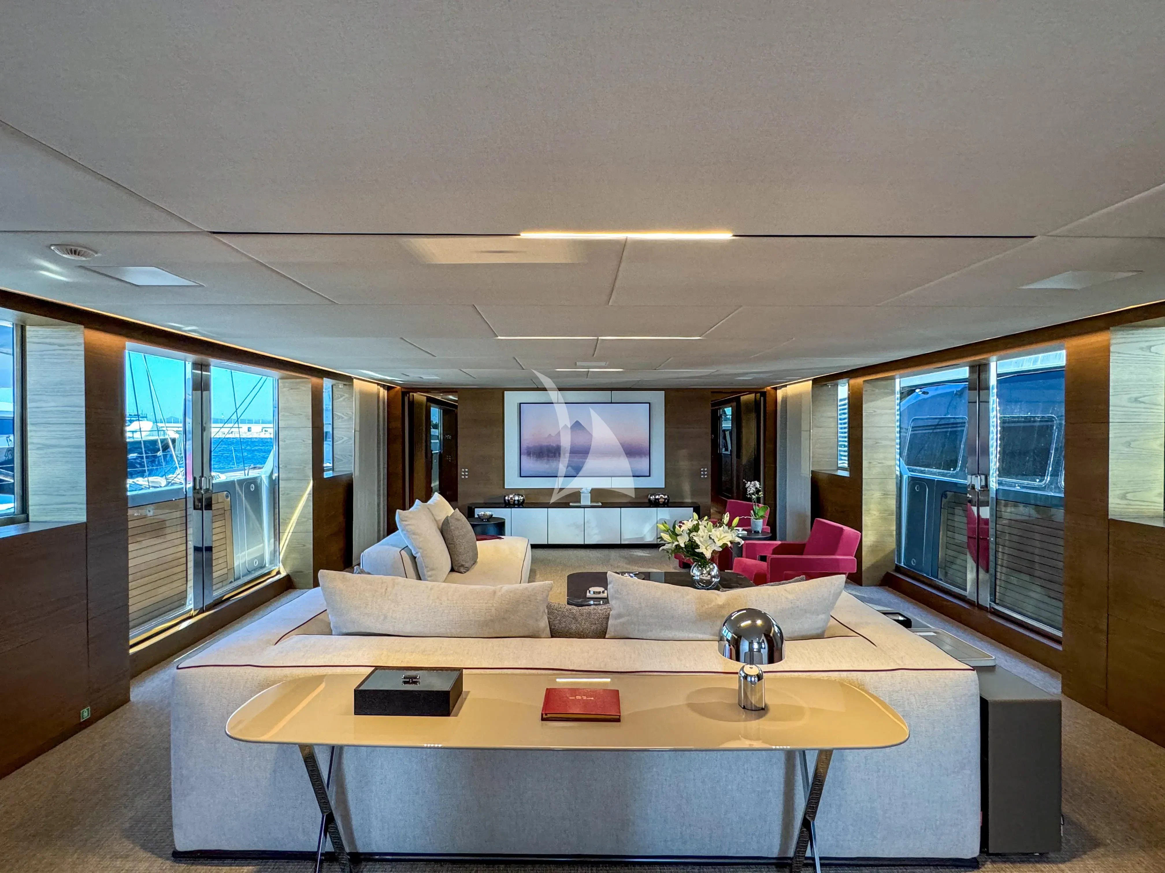 a living room with a table and couches aboard NAIA Yacht for Sale