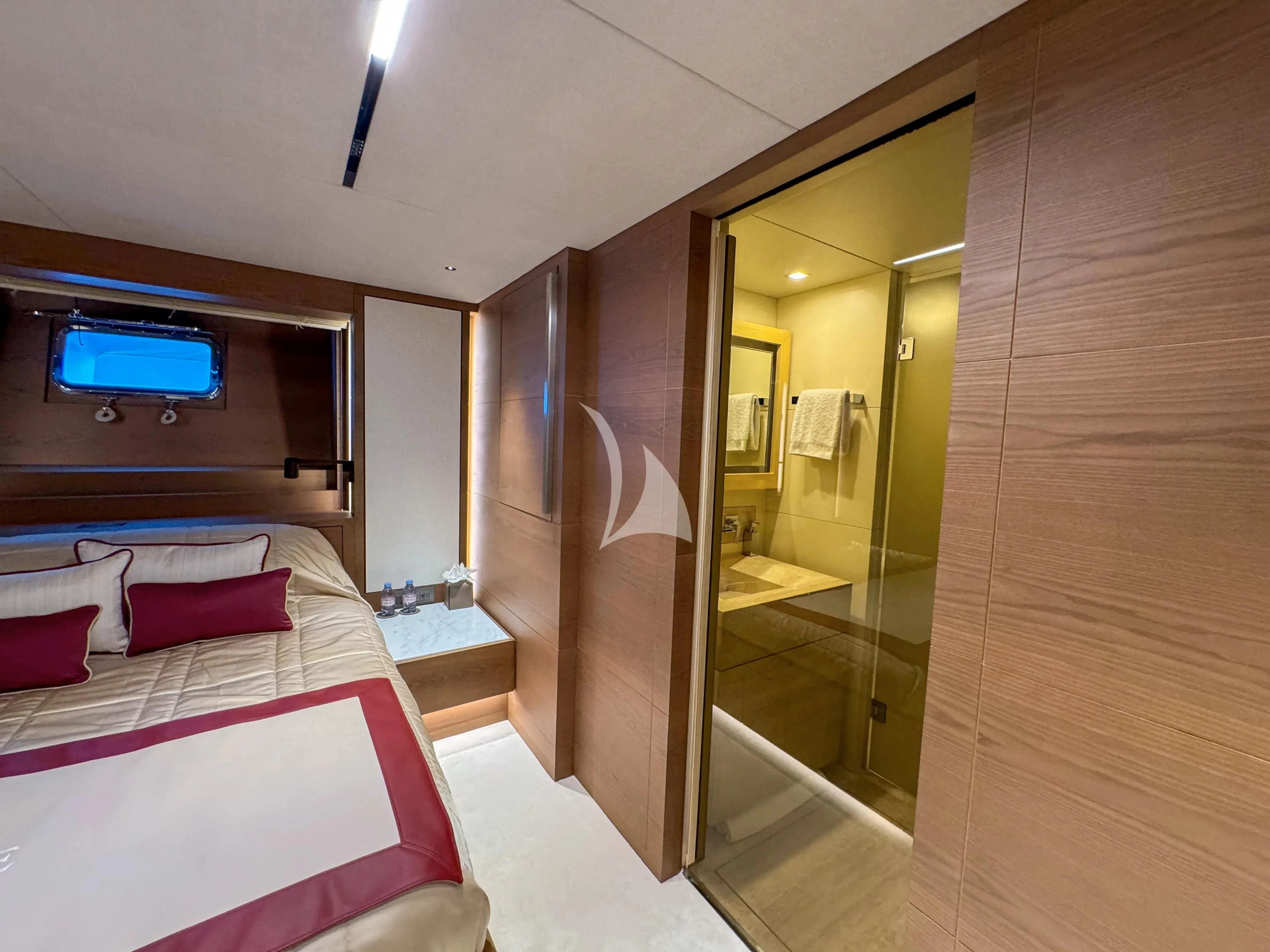 a room with a bed and a mirror aboard NAIA Yacht for Sale