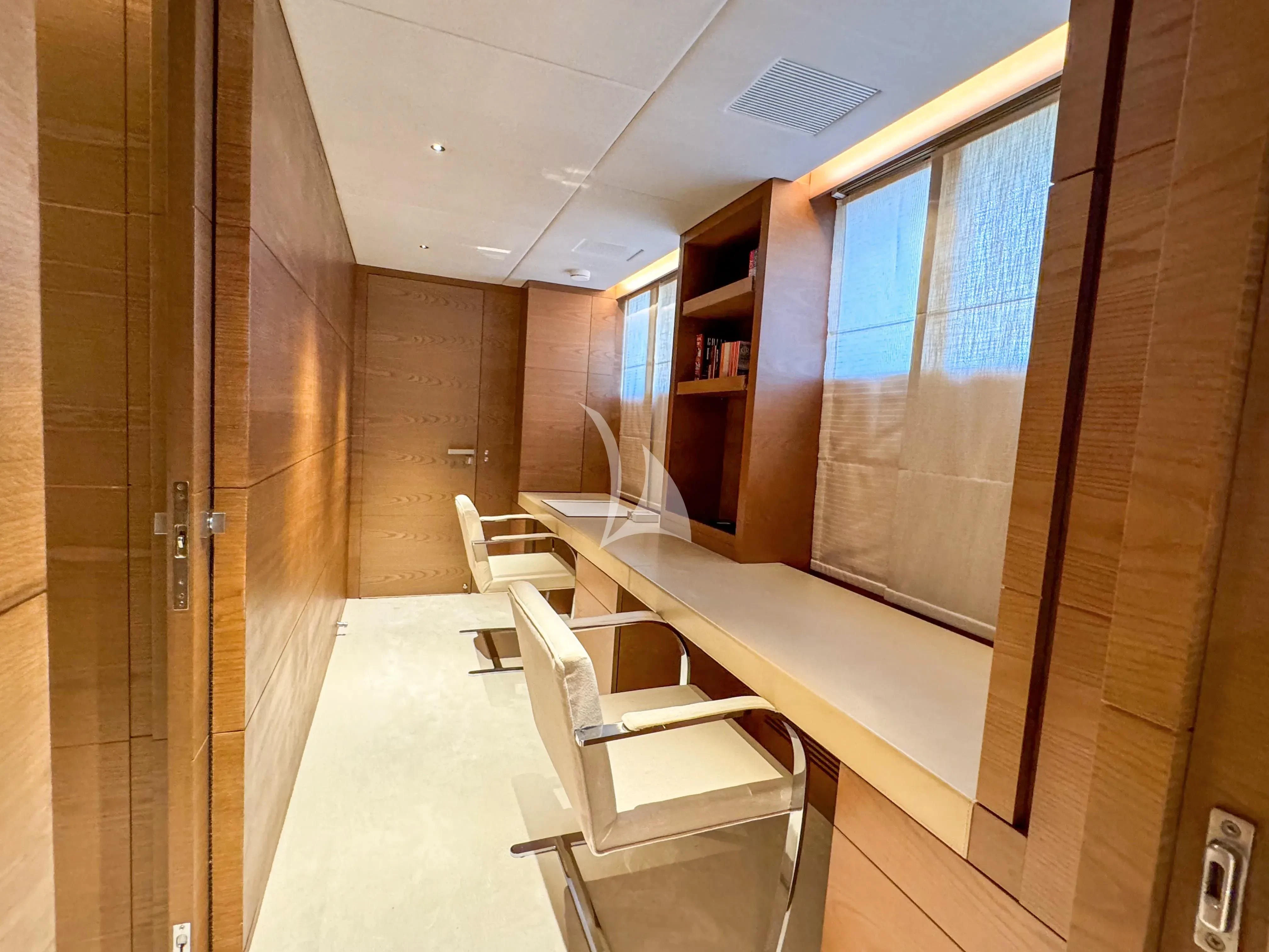 a room with a long table and chairs aboard NAIA Yacht for Sale