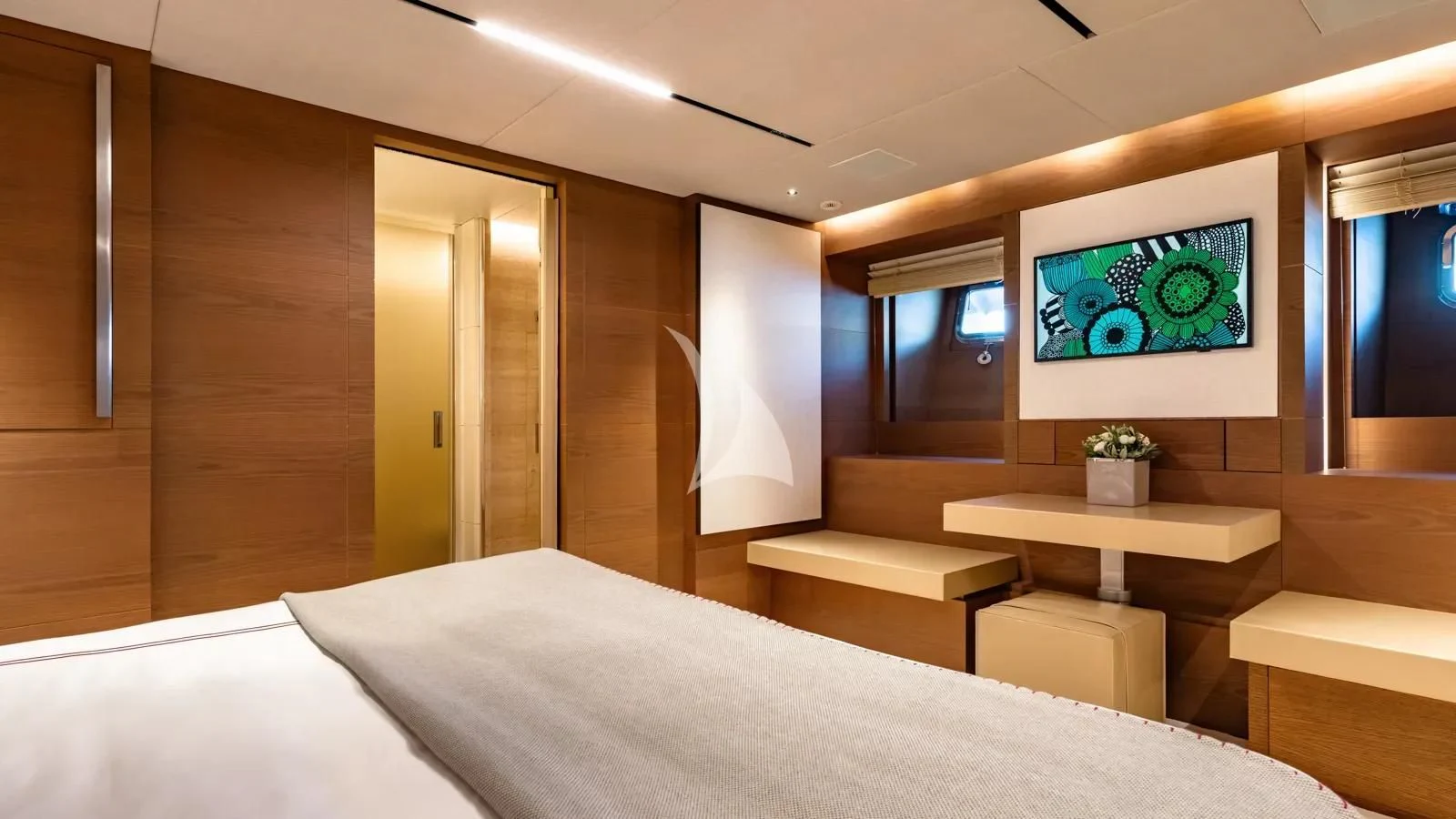 a room with a bed and a painting on the wall aboard NAIA Yacht for Sale