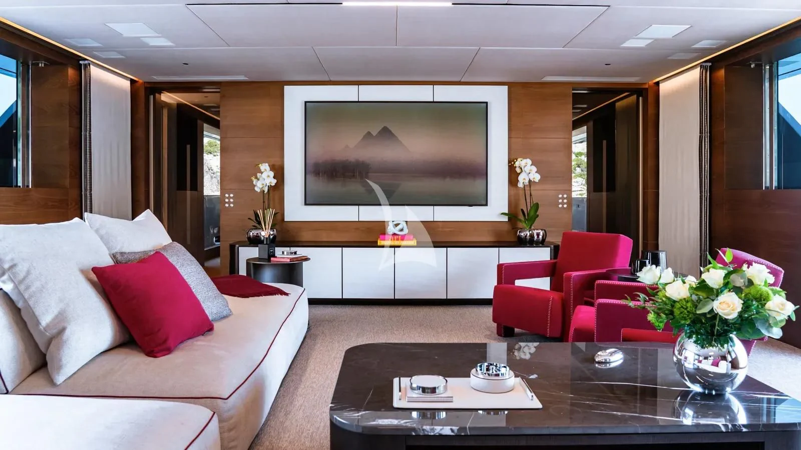 a living room with a table and a tv aboard NAIA Yacht for Sale