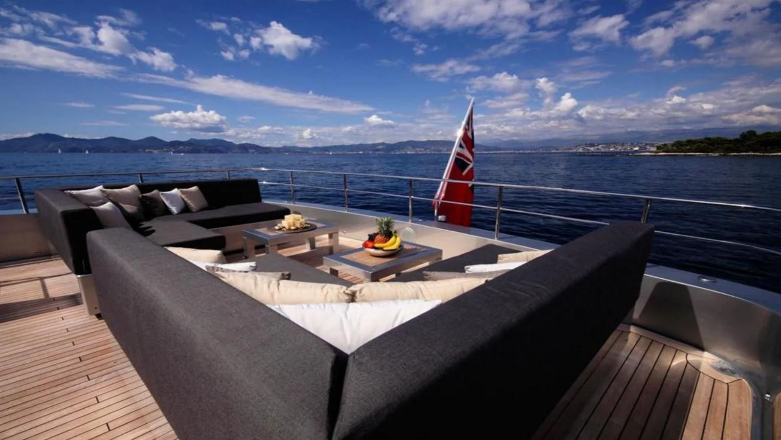 a large white bed on a deck overlooking a large body of water aboard NAIA Yacht for Sale