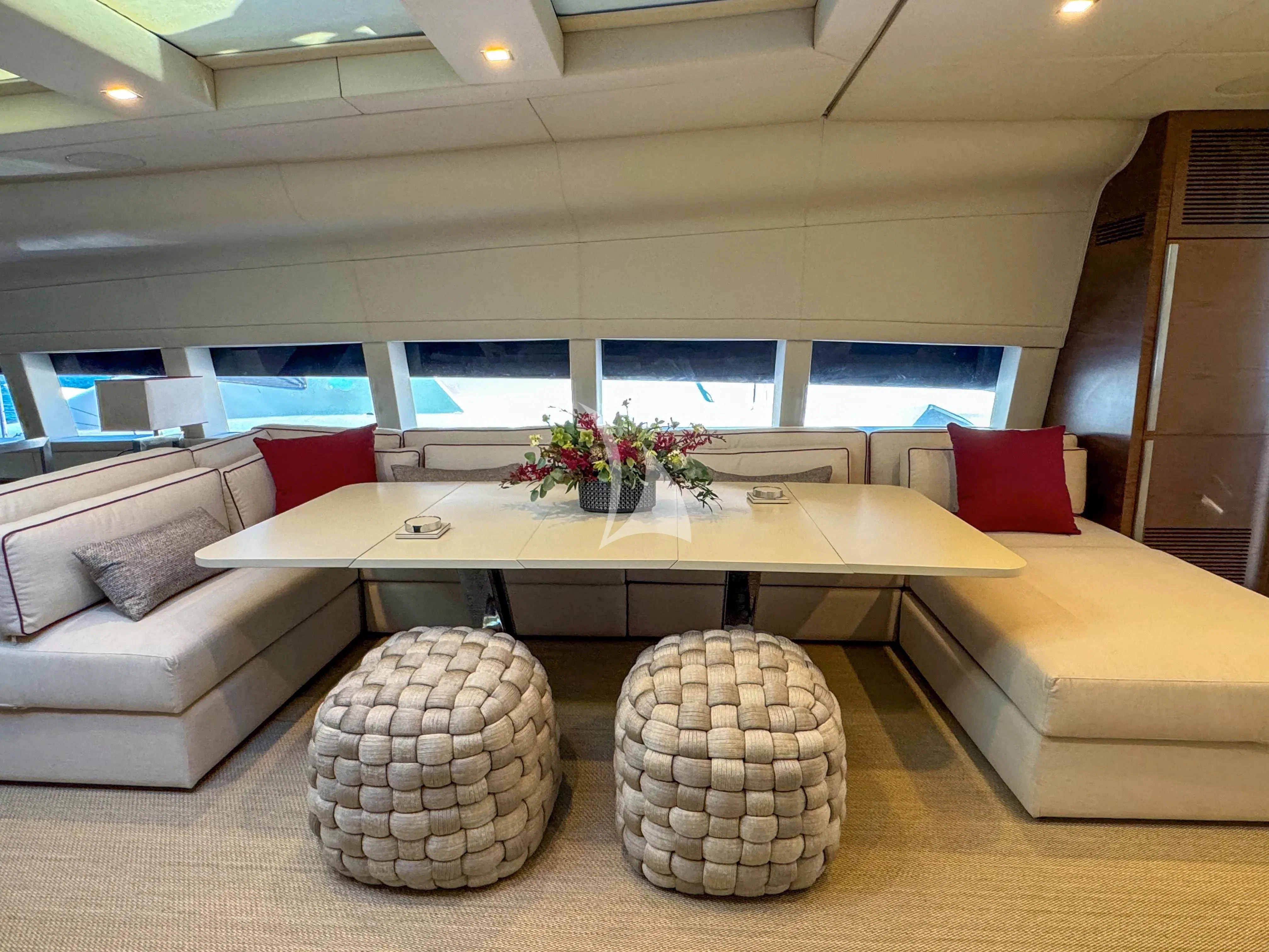 a room with a couch and a table with a vase on it aboard NAIA Yacht for Sale