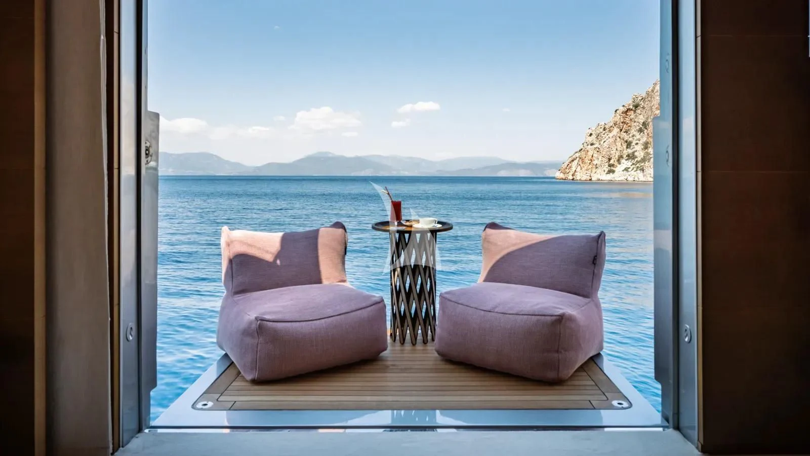 a window with a view of the ocean and mountains aboard NAIA Yacht for Sale