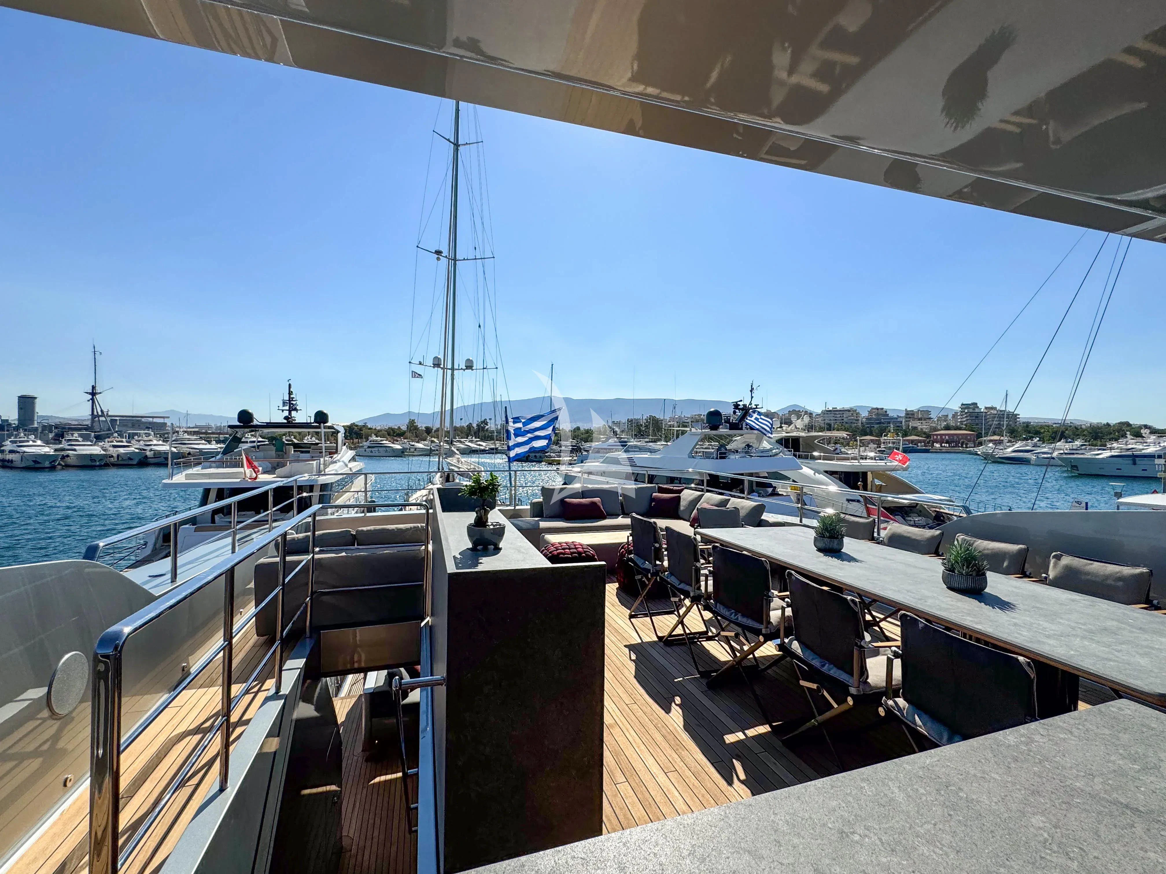 a deck with a view of a marina and boats aboard NAIA Yacht for Sale