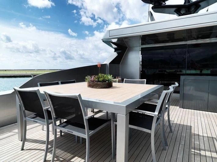 a table and chairs on a deck aboard NAIA Yacht for Sale