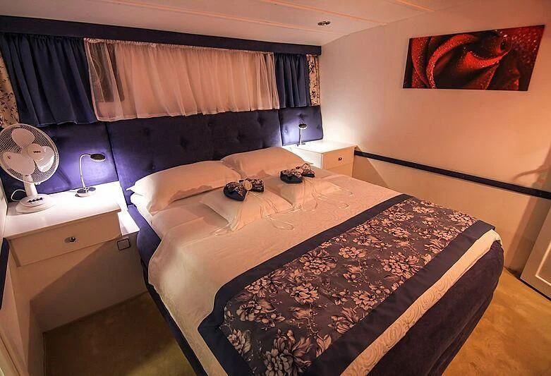 a bedroom with a bed and a lamp aboard AURUM Yacht for Sale