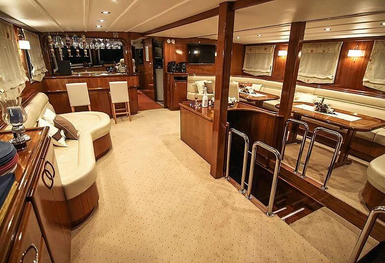 a room with a bar and chairs aboard AURUM Yacht for Sale
