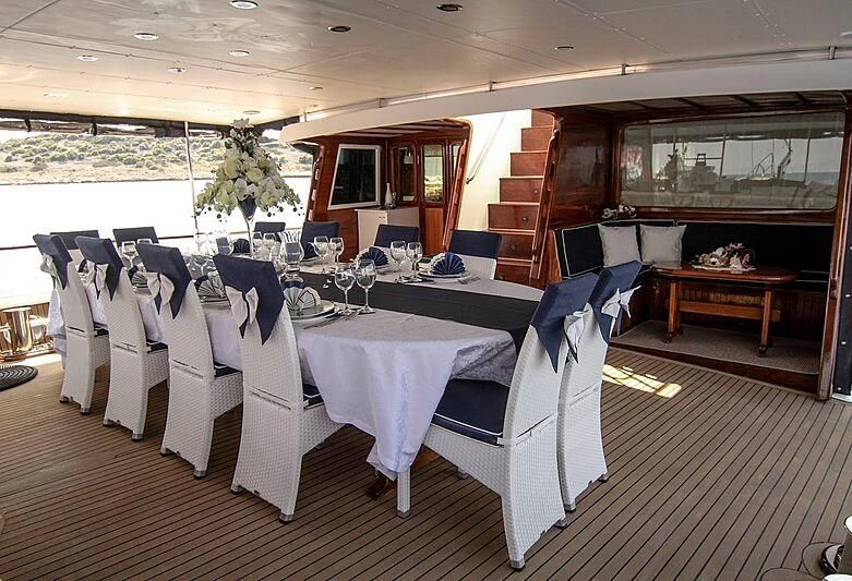 a room with tables and chairs aboard AURUM Yacht for Sale