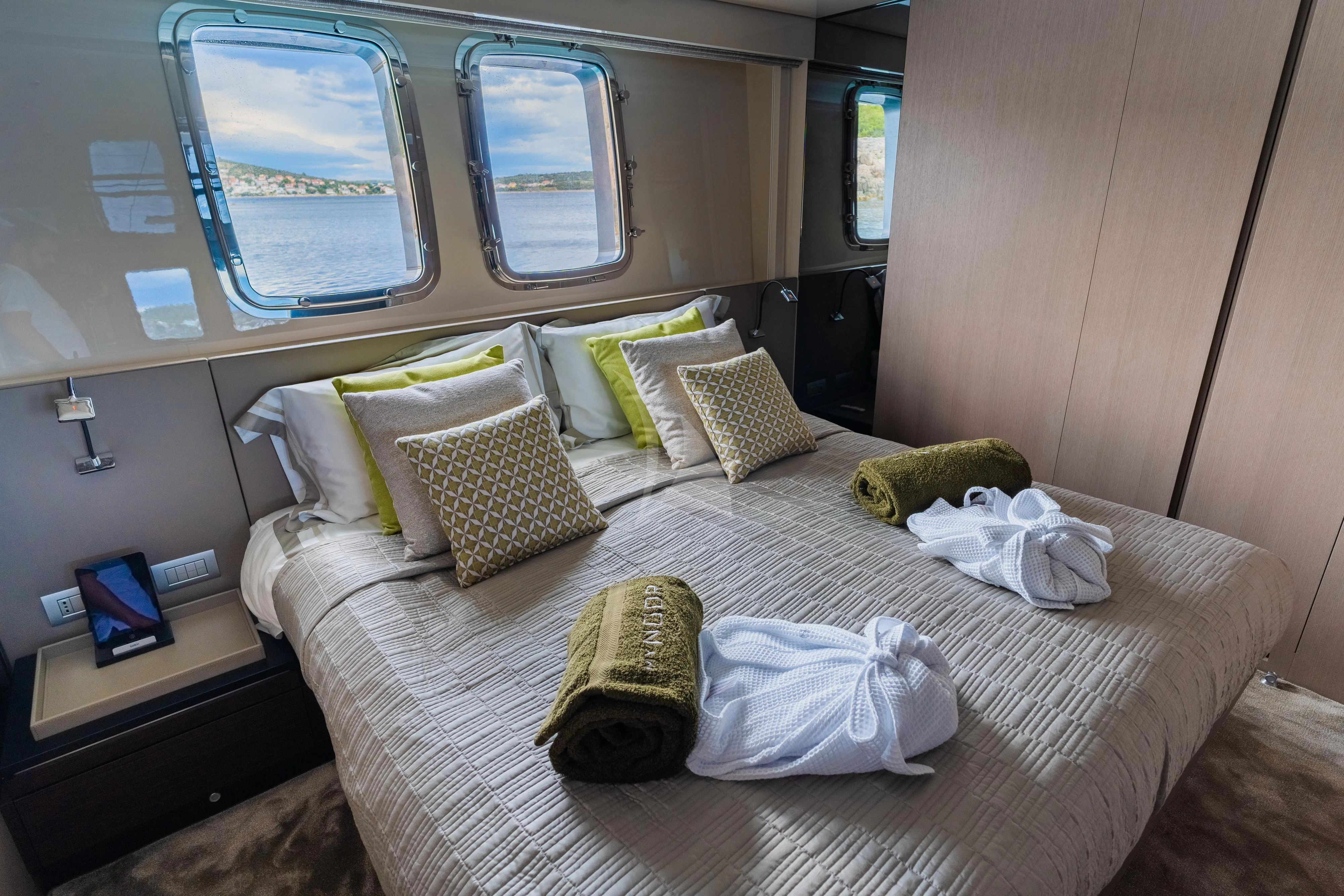 a bed with a white sheet and pillows on it aboard NOOR II Yacht for Charter