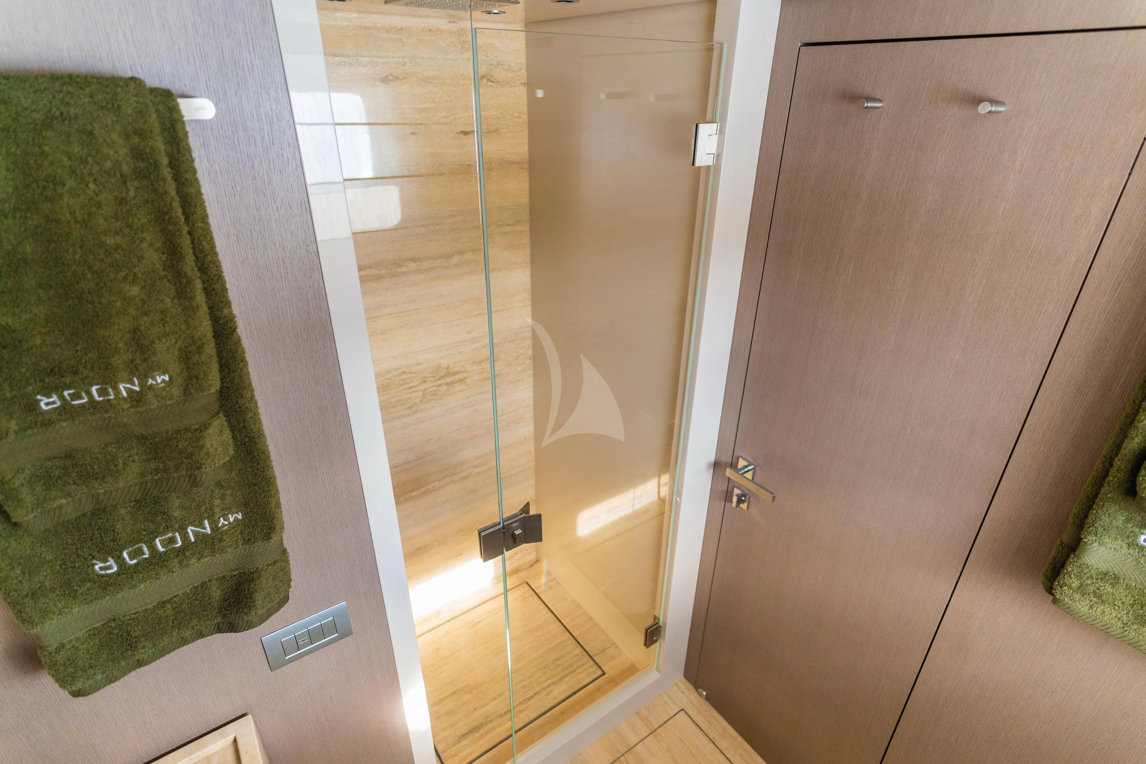 a green bag next to a brown door aboard NOOR II Yacht for Charter