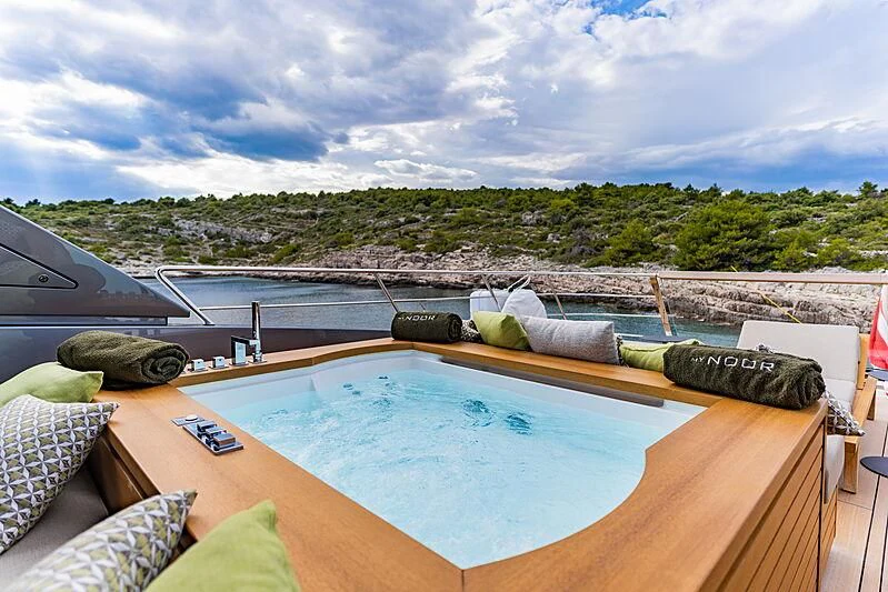 a pool with a large building in the background aboard NOOR II Yacht for Charter