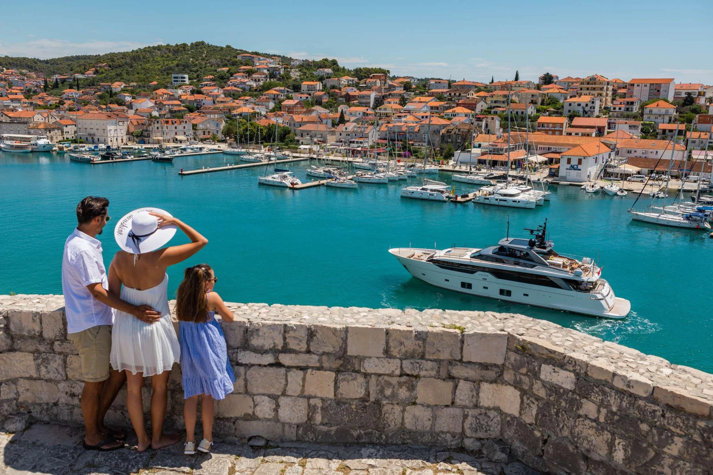a group of people looking at boats in the water aboard NOOR II Yacht for Charter