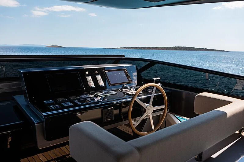 a car with a steering wheel and dashboard and a body of water in the background aboard NOOR II Yacht for Charter