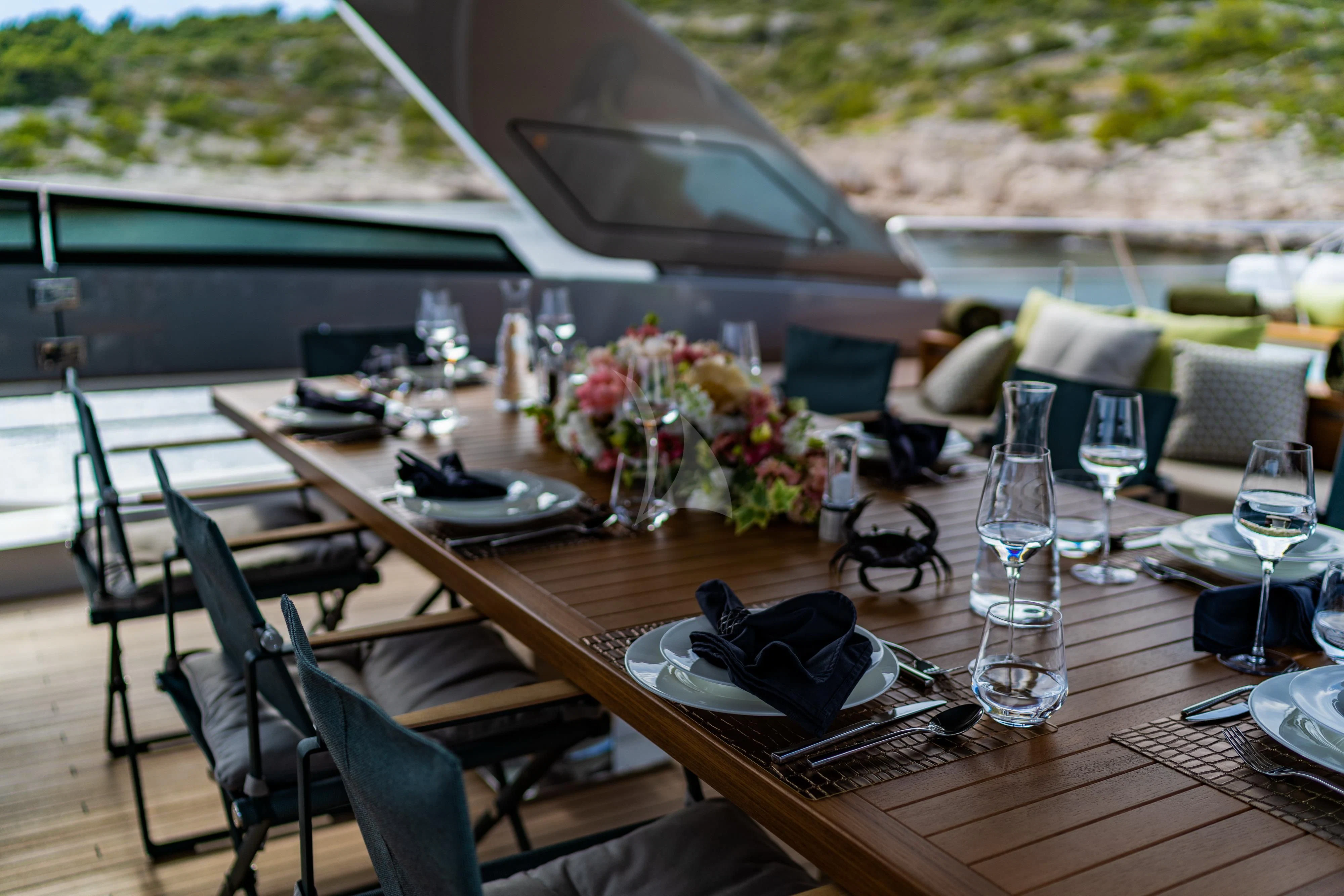 a table with chairs and a couple of glasses on it aboard NOOR II Yacht for Charter