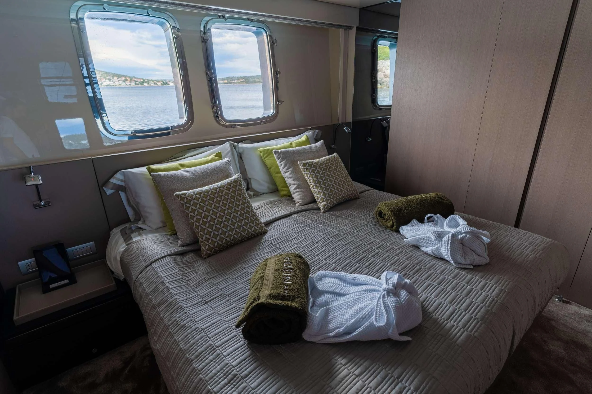 a bed with pillows and blankets aboard NOOR II Yacht for Charter