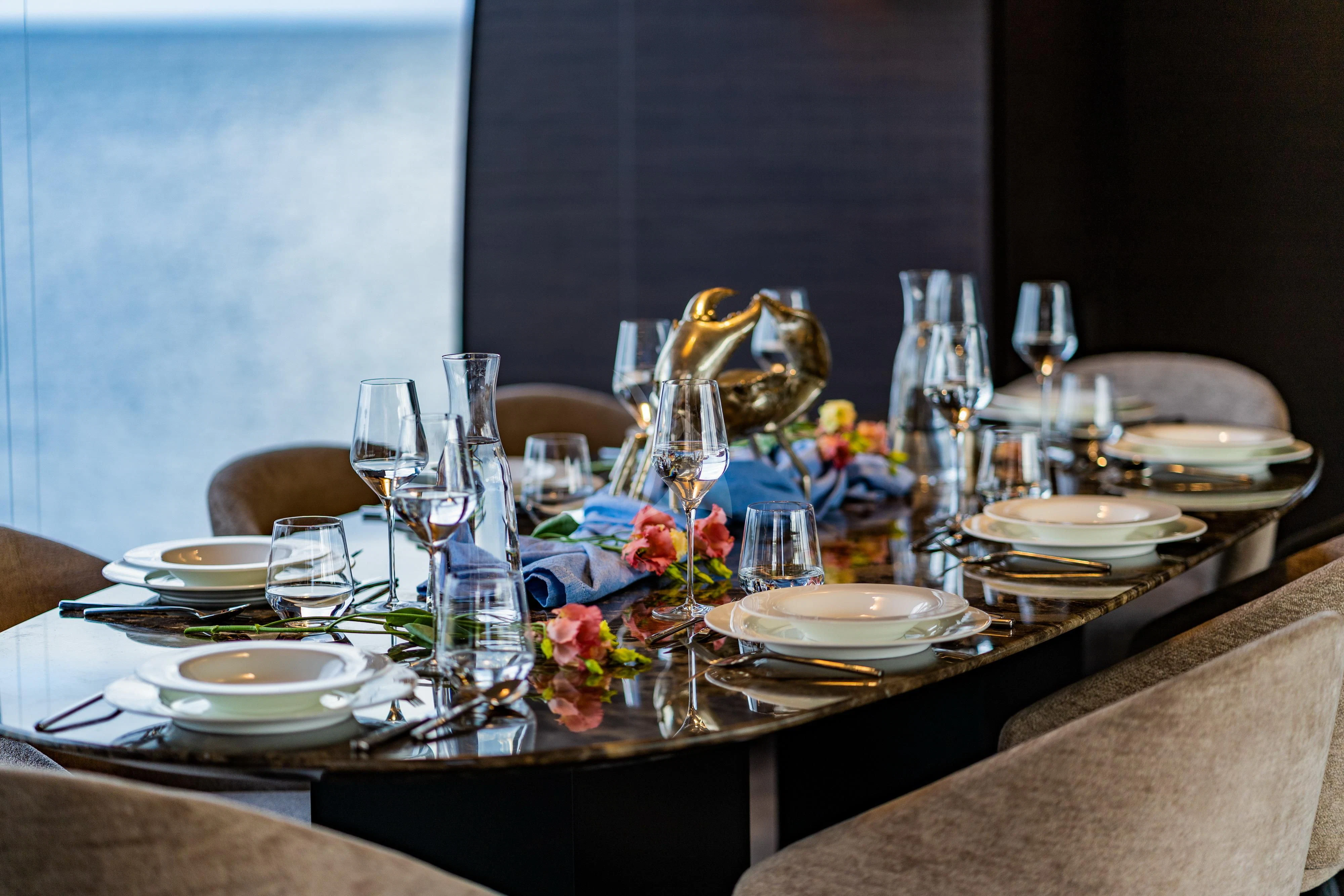 a table set with plates and glasses aboard NOOR II Yacht for Charter