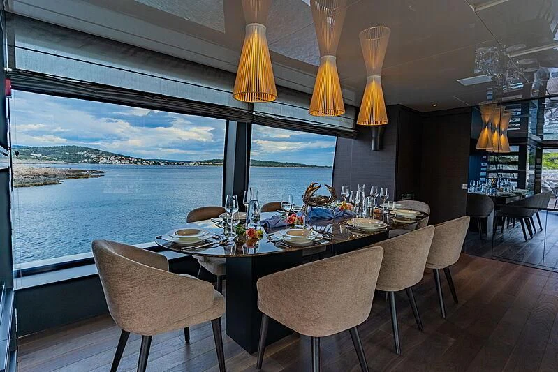 a dining table with a view of the ocean and the ocean aboard NOOR II Yacht for Charter