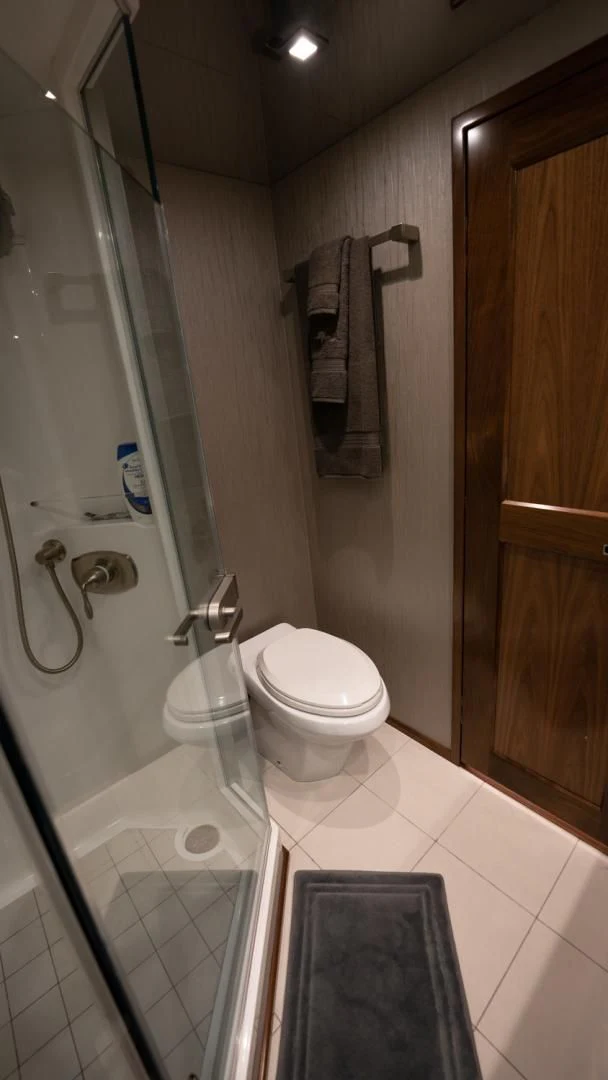 a bathroom with a toilet and a shower aboard WHY WOULDN'T WE Yacht for Sale